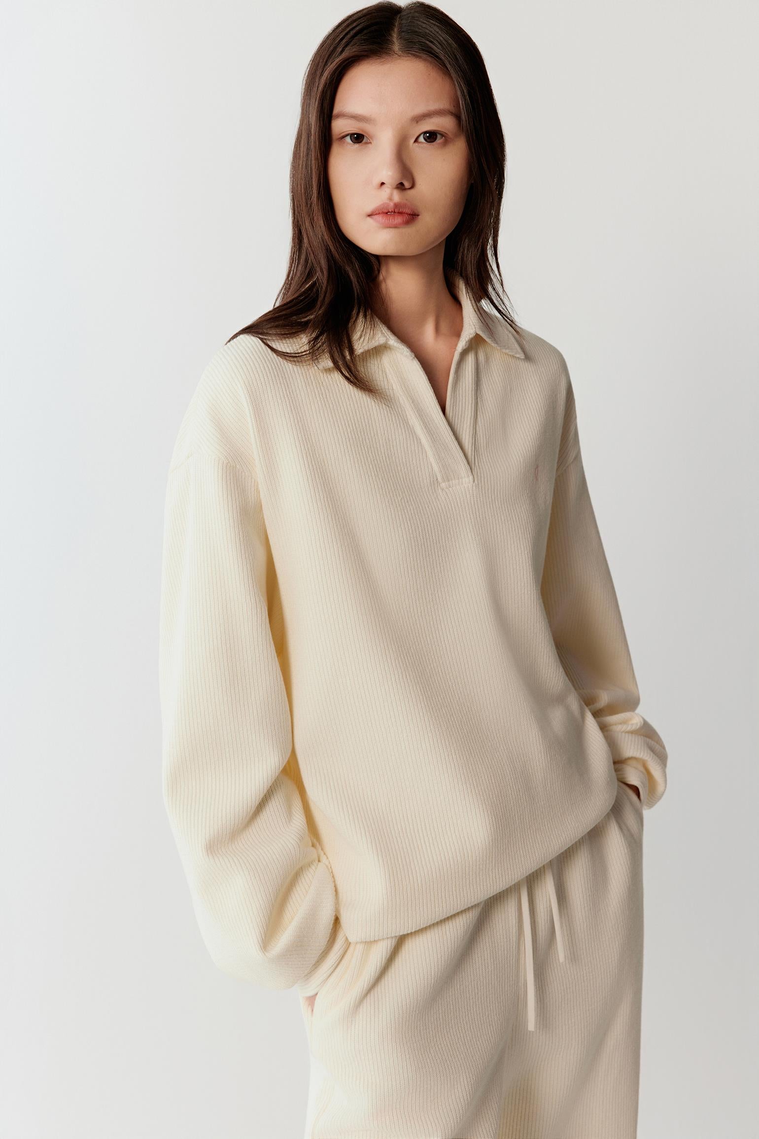 Front view highlighting the open collar and the relaxed shape of the sweater through the shoulders and torso.