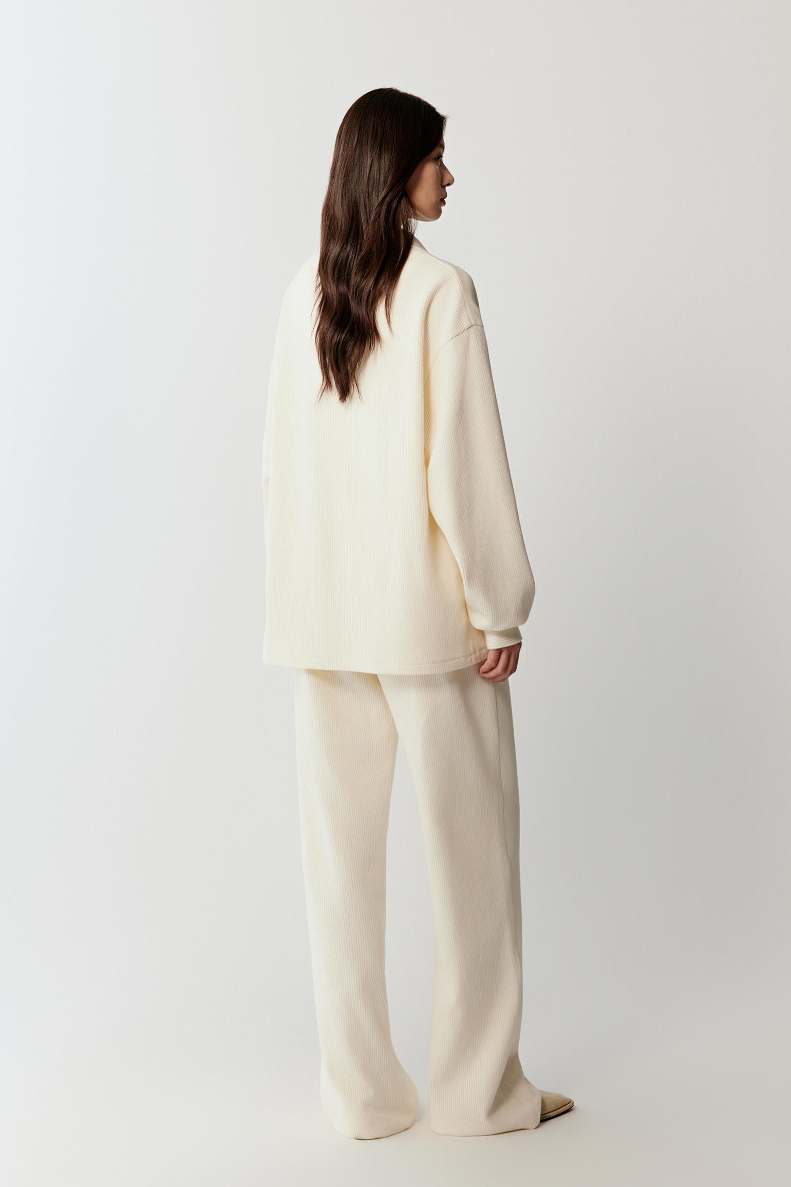 Back view showing the clean construction and the smooth drape of the stretch rib jersey fabric across the back.