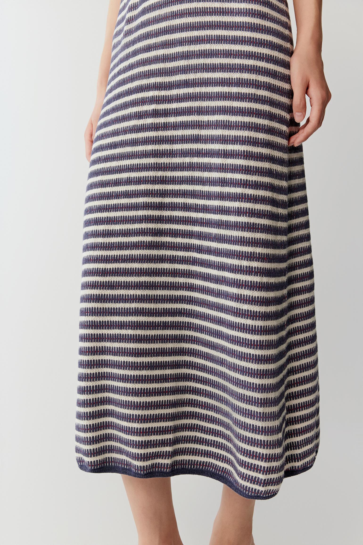 Close-up of the lower skirt area showing the lightweight knitted texture, stripe alignment and natural fluidity of the linen and silk yarn construction