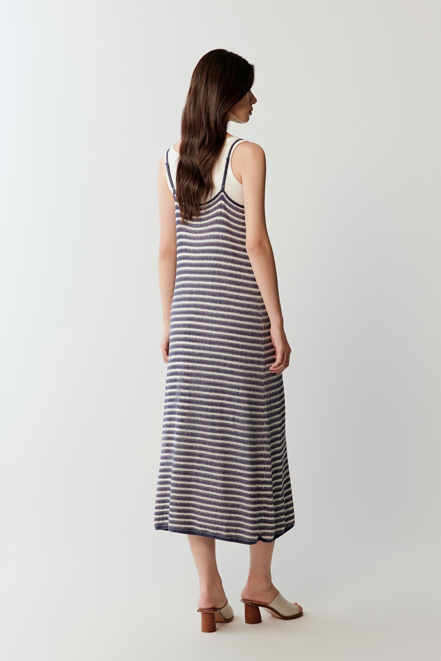 Full-length side view showing the elongated silhouette and fluid movement of the dress, emphasizing the soft drape and lightweight structure of the fabric
