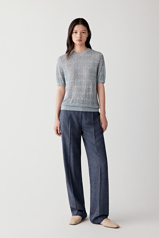 Full-length front view showing the pullover paired with dark blue trousers, emphasizing the fluid fit, lightweight structure and naturally relaxed drape of the cotton and silk knit fabric