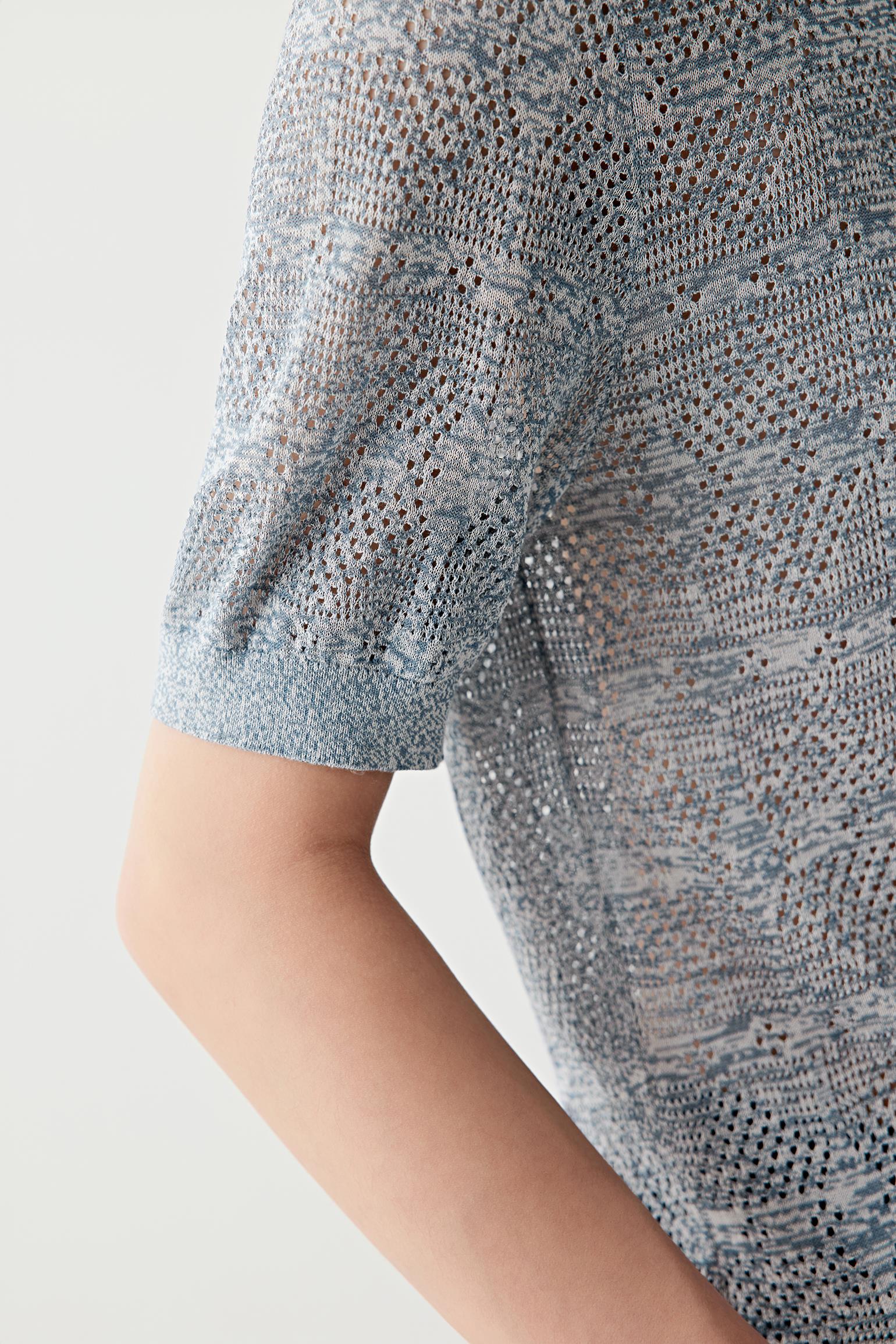 Close-up of sleeve and side seam showing the ribbed finishing, knit construction and soft dry texture of the cotton and silk yarn blend