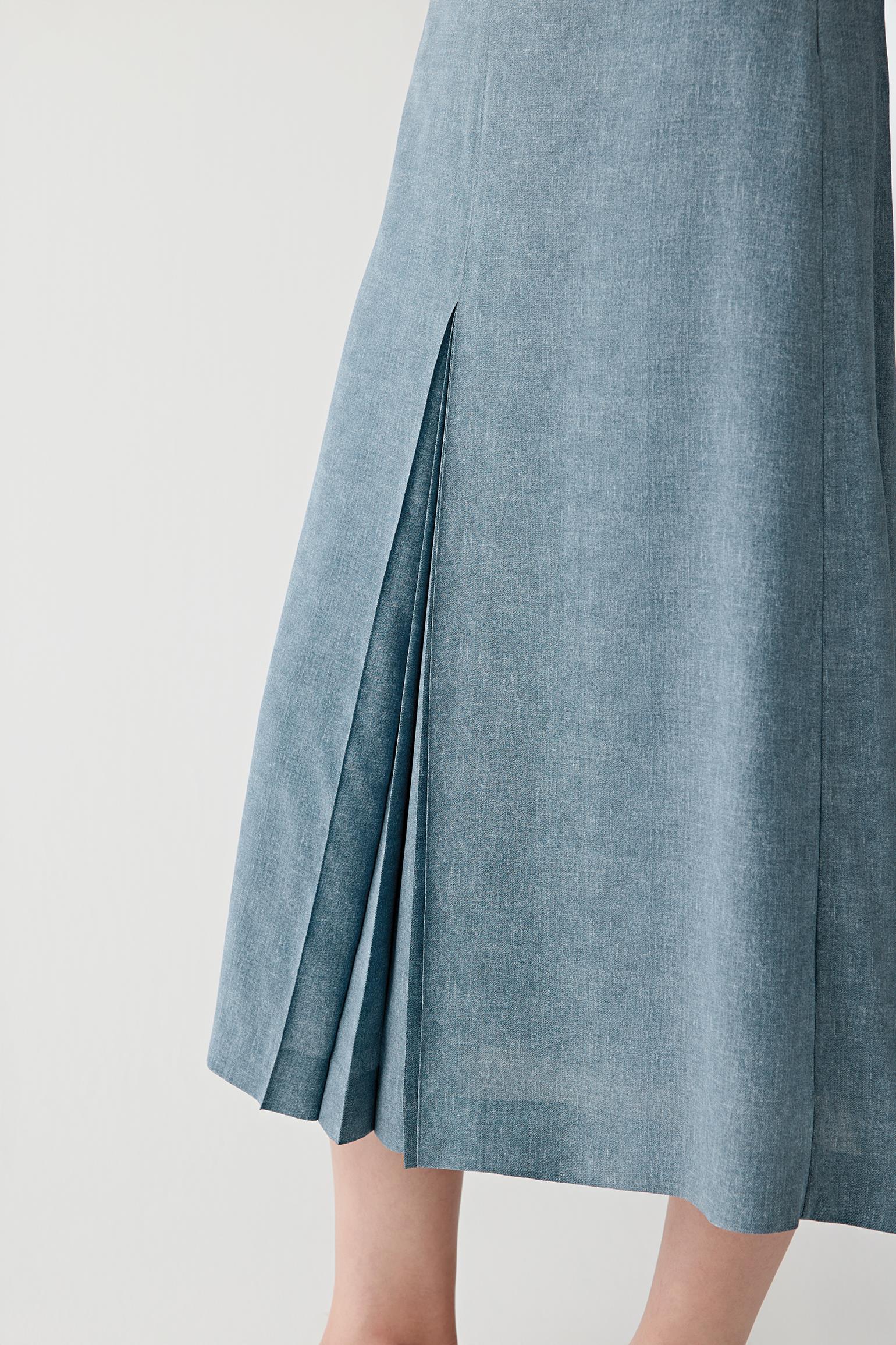 Close-up of the lower pleated section showing the layered pleat construction, soft drape and lightweight texture with fluid movement through the hemline
