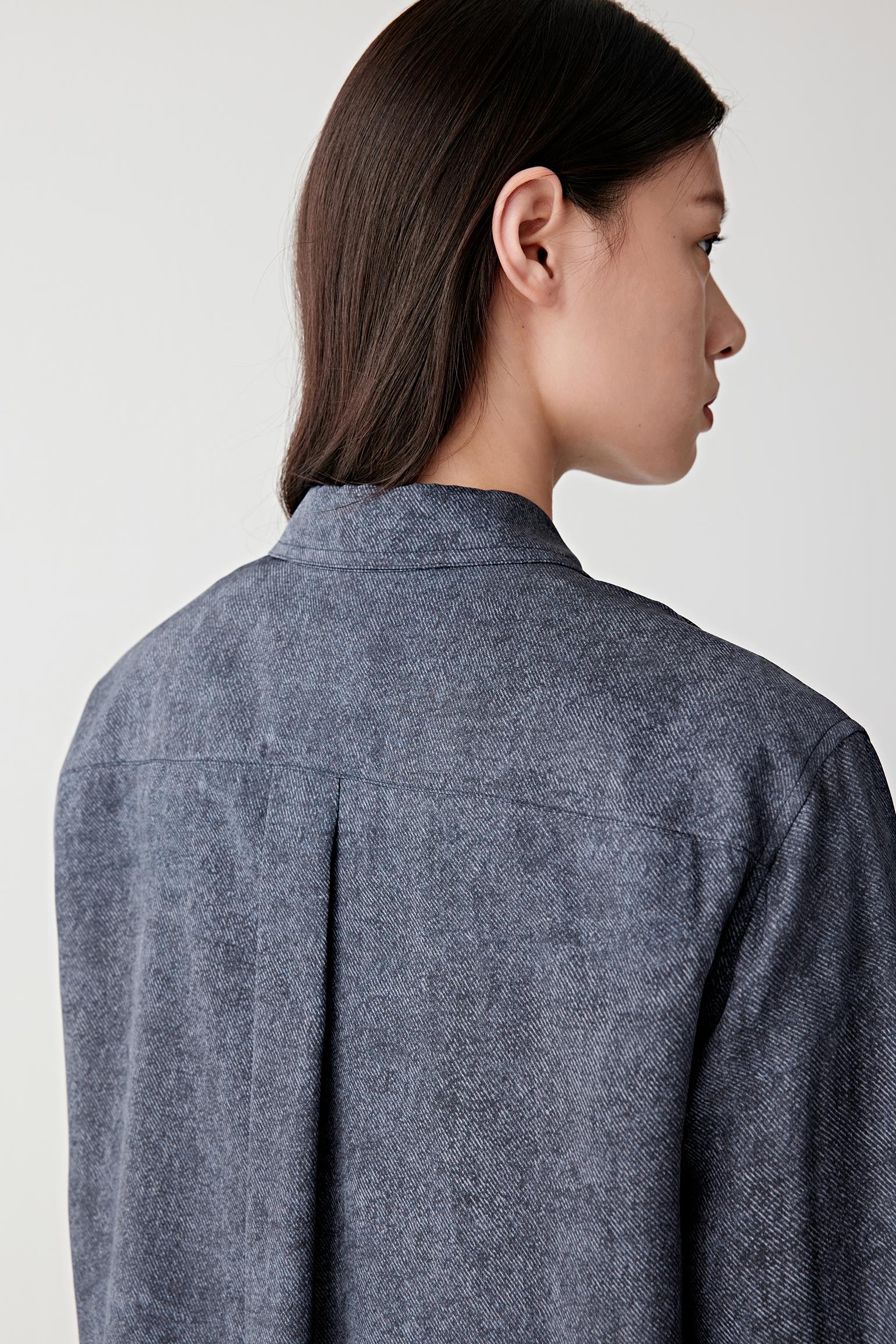 Close-up of sleeve and hem showing visible stitching, lightweight drape and the smooth fluid texture characteristic of silk twill construction