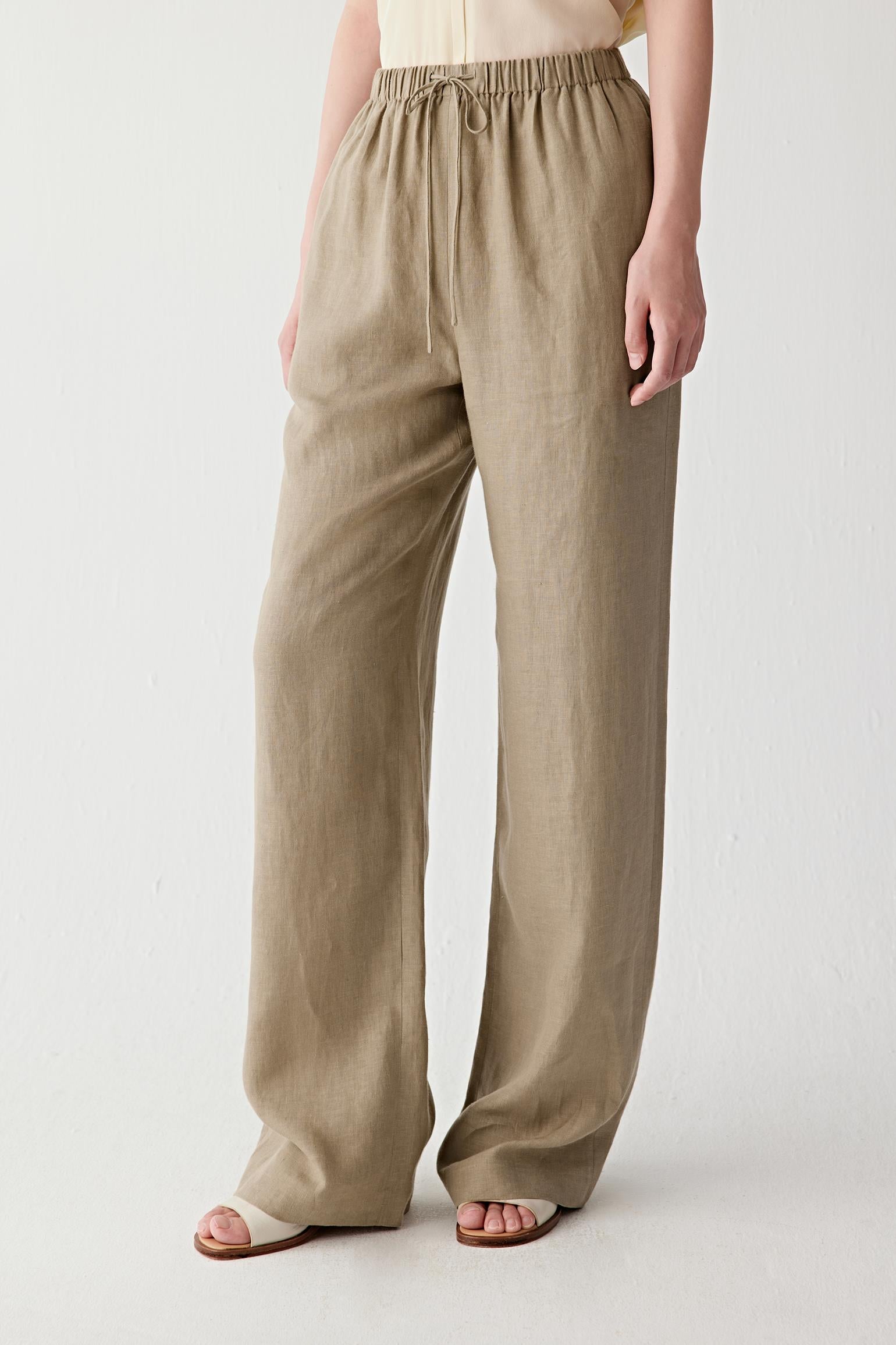 Side view showing the straight cut and natural fall of the linen fabric from the elasticated waistband. The lightweight weave creates soft movement while preserving the clean line of the leg.