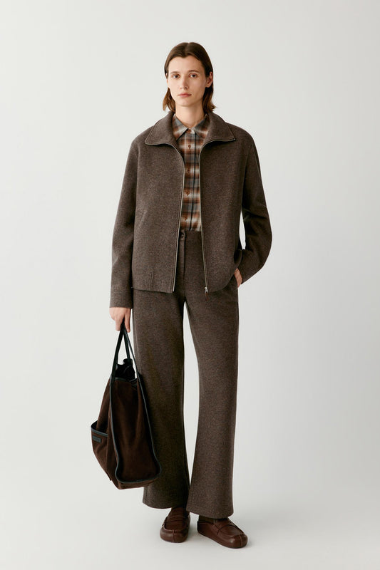 Front view of a woman wearing a brown melange wool and cashmere jersey blouson, showing the stand collar, zip front and welt pockets.