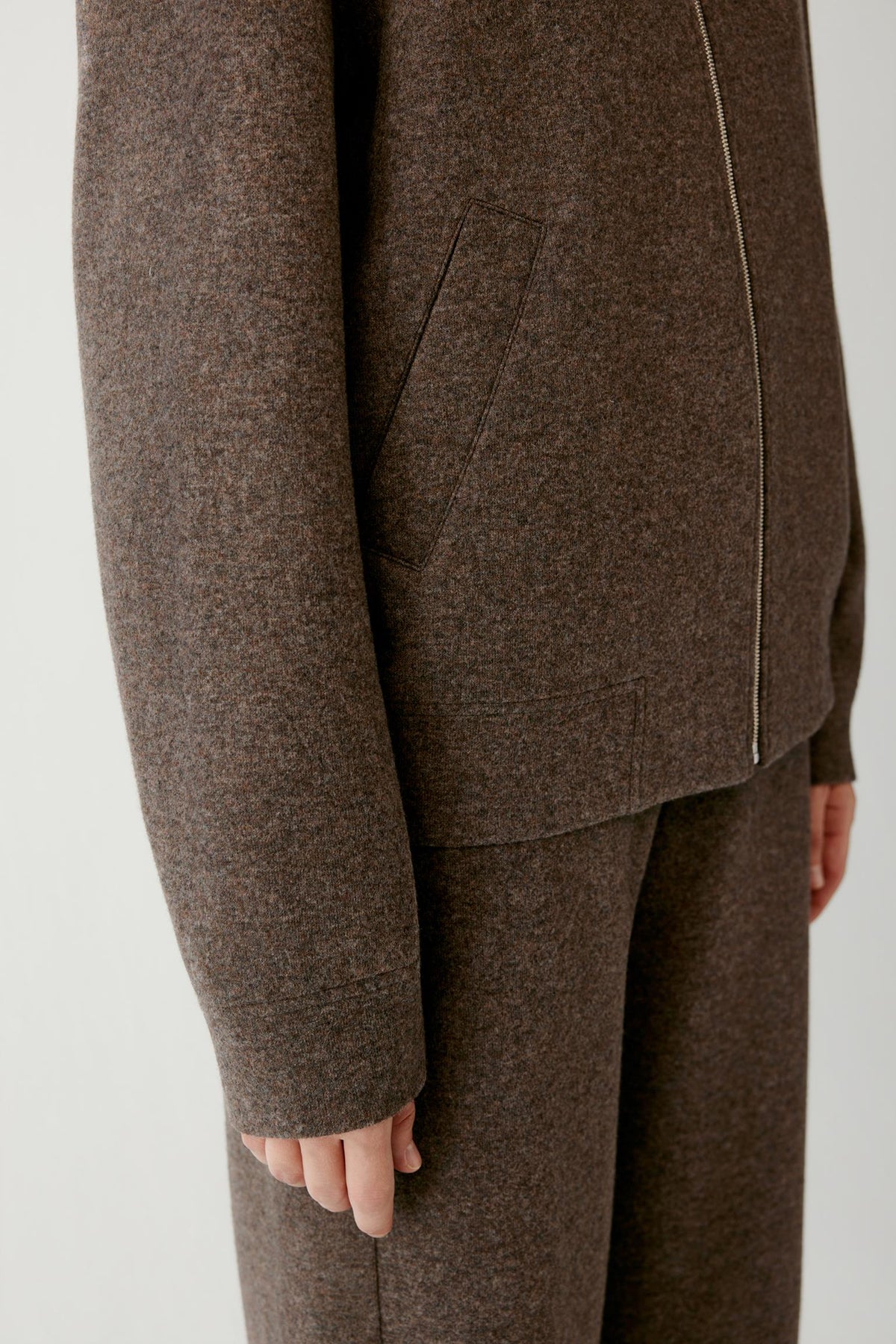 Close-up highlighting the long sleeve and brown melange wool and cashmere jersey texture.