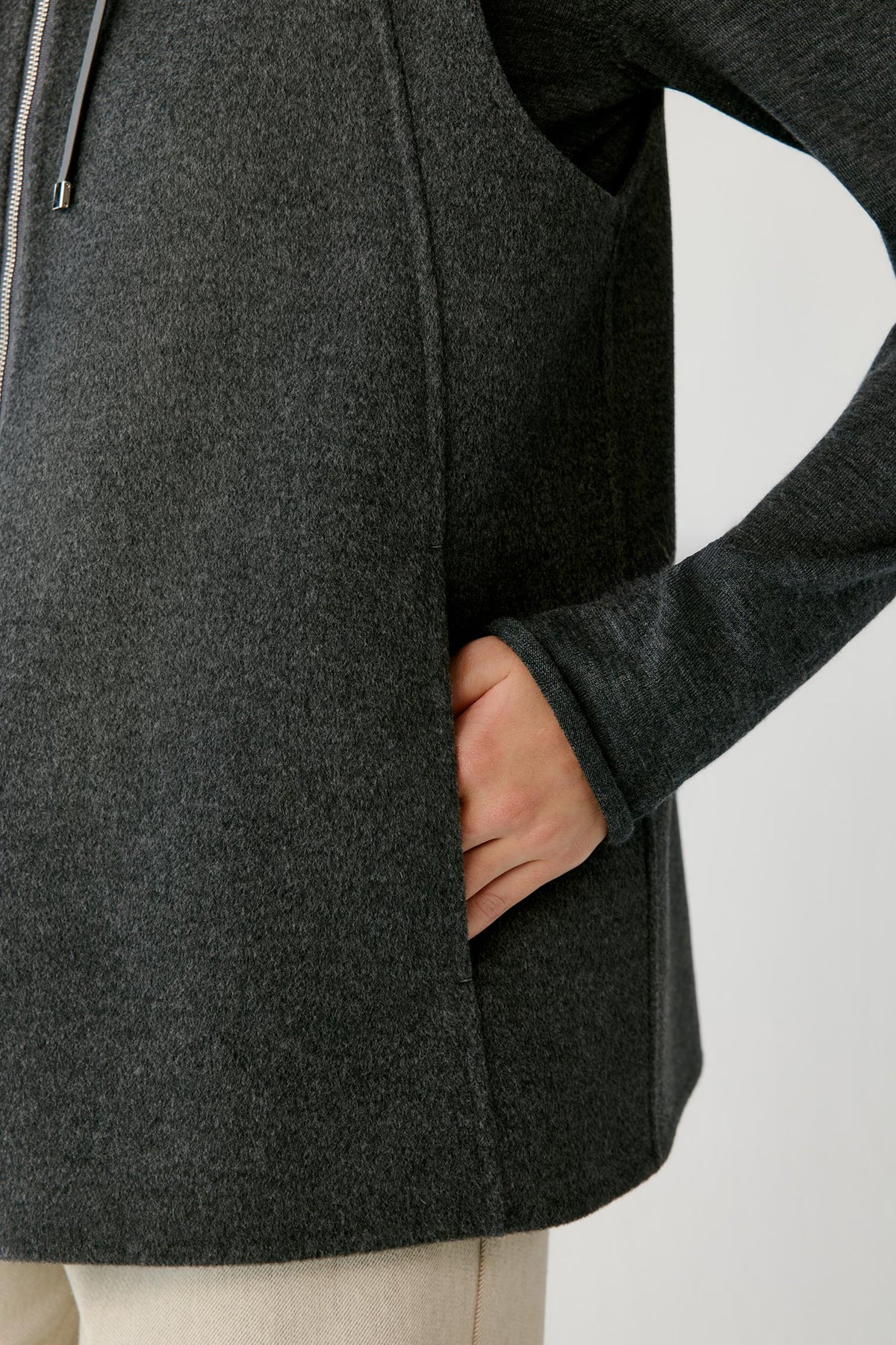 Close-up highlighting the side pocket and textured double-face surface of the dark grey melange coat.