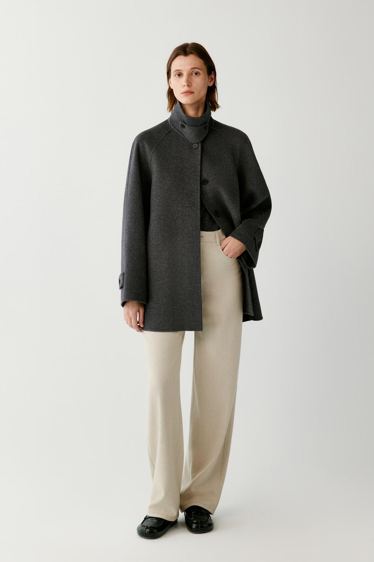 Front full-length view of a woman wearing the dark grey melange wool and cashmere coat, highlighting the high stand collar and straight silhouette.
