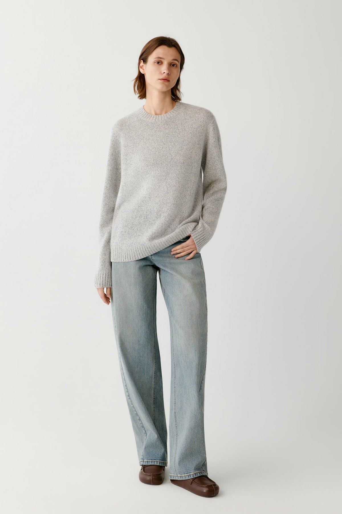 Front view of a woman wearing a blue and white melange cashmere and silk pullover, showing the crew neckline, long sleeves and relaxed silhouette.