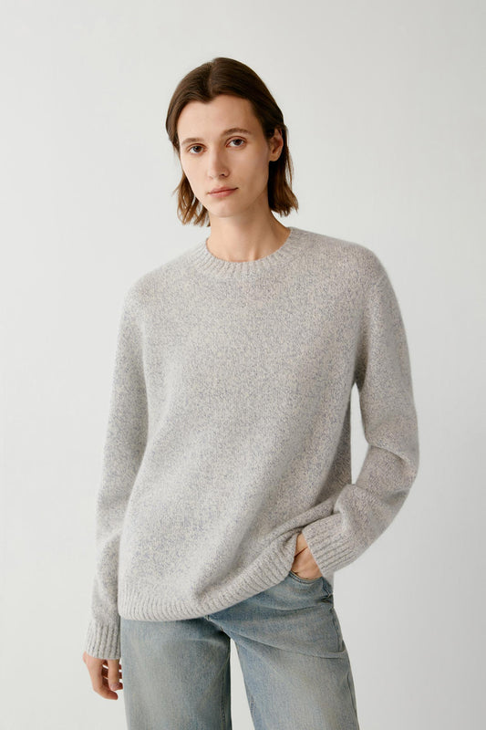 Front view highlighting the crew neckline, long sleeves and lightly brushed texture of the blue and white melange pullover.