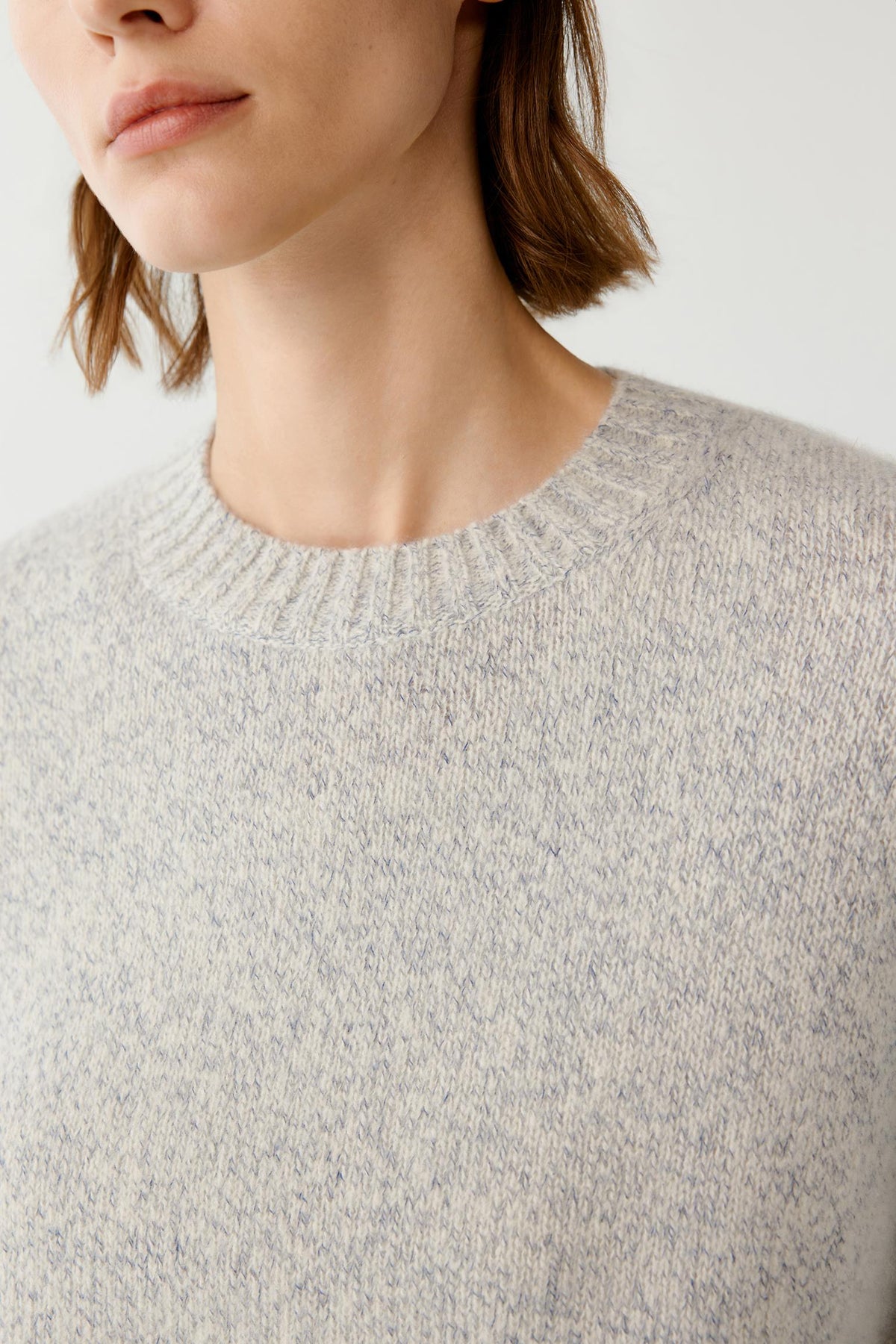 Close-up highlighting the crew neckline and lightly brushed melange texture of the cashmere and silk pullover.