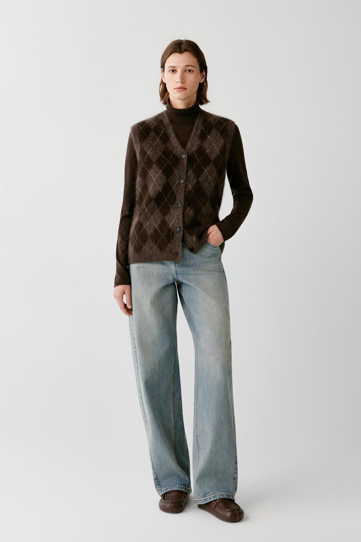 Front full-length view of a woman wearing the dark brown yak sleeveless pullover, highlighting the argyle pattern and straight silhouette.