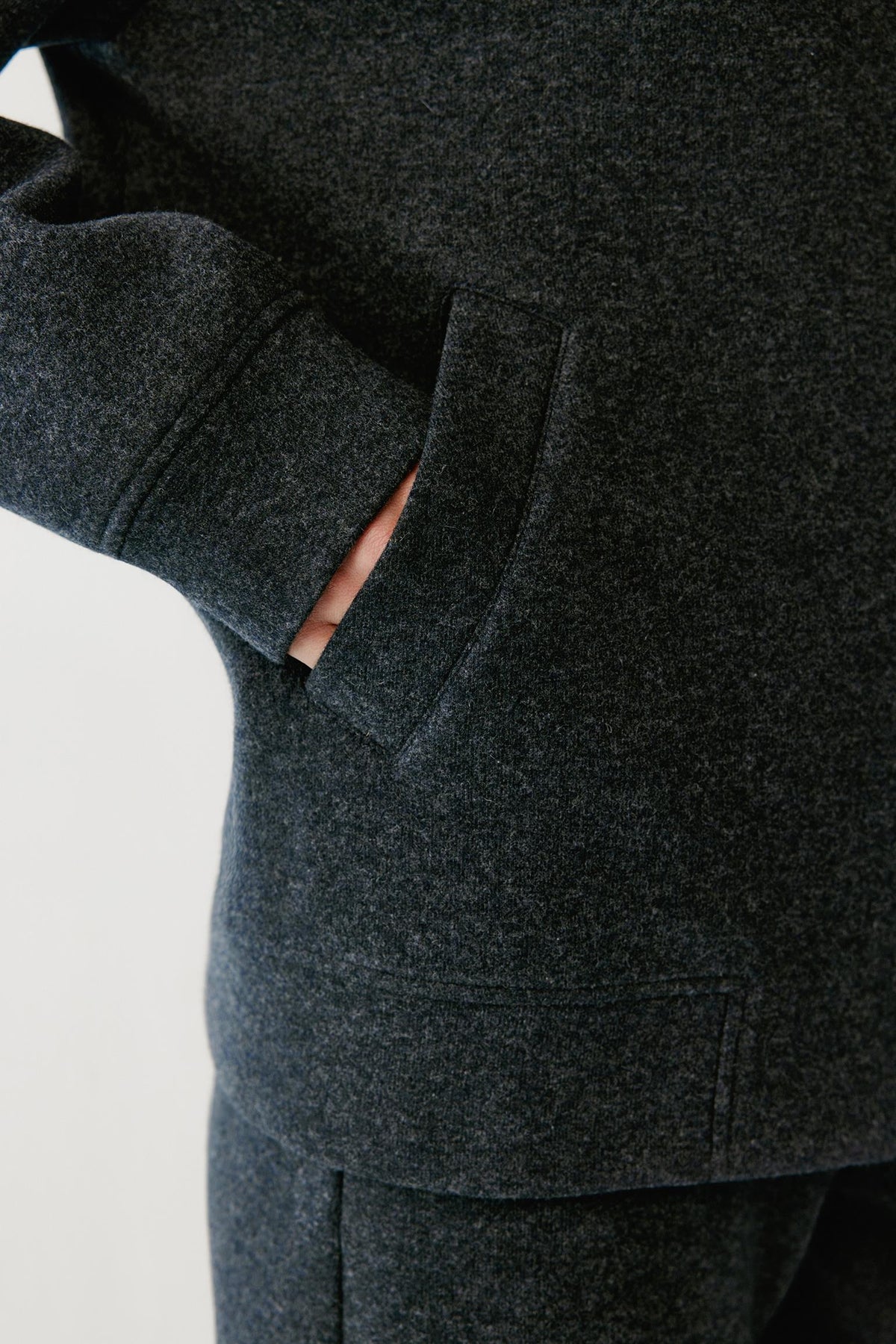 Close-up highlighting the welt pocket and grey melange wool and cashmere jersey texture.