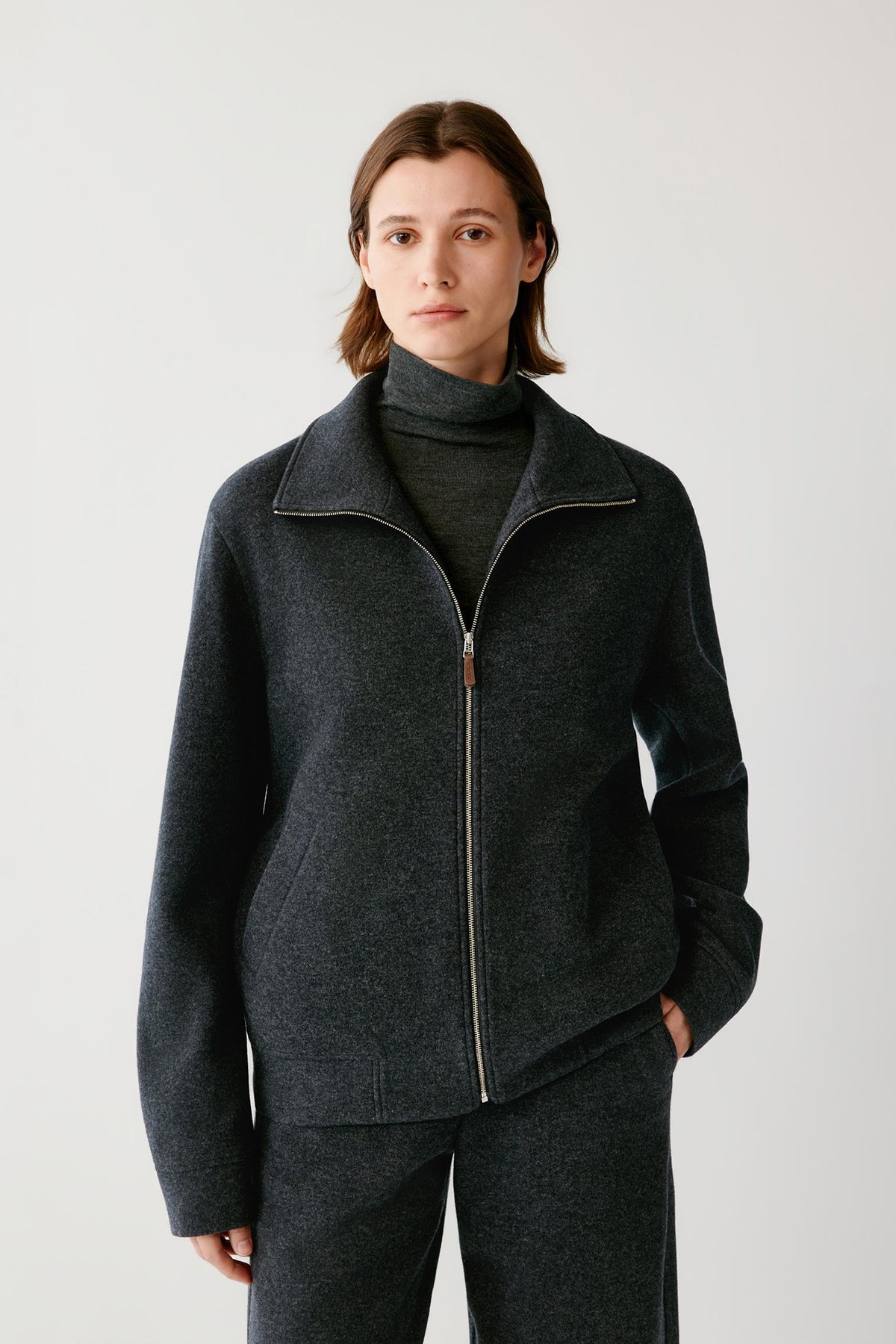 Front view highlighting the stand collar, two-way zip fastening and straight silhouette of the grey melange blouson.