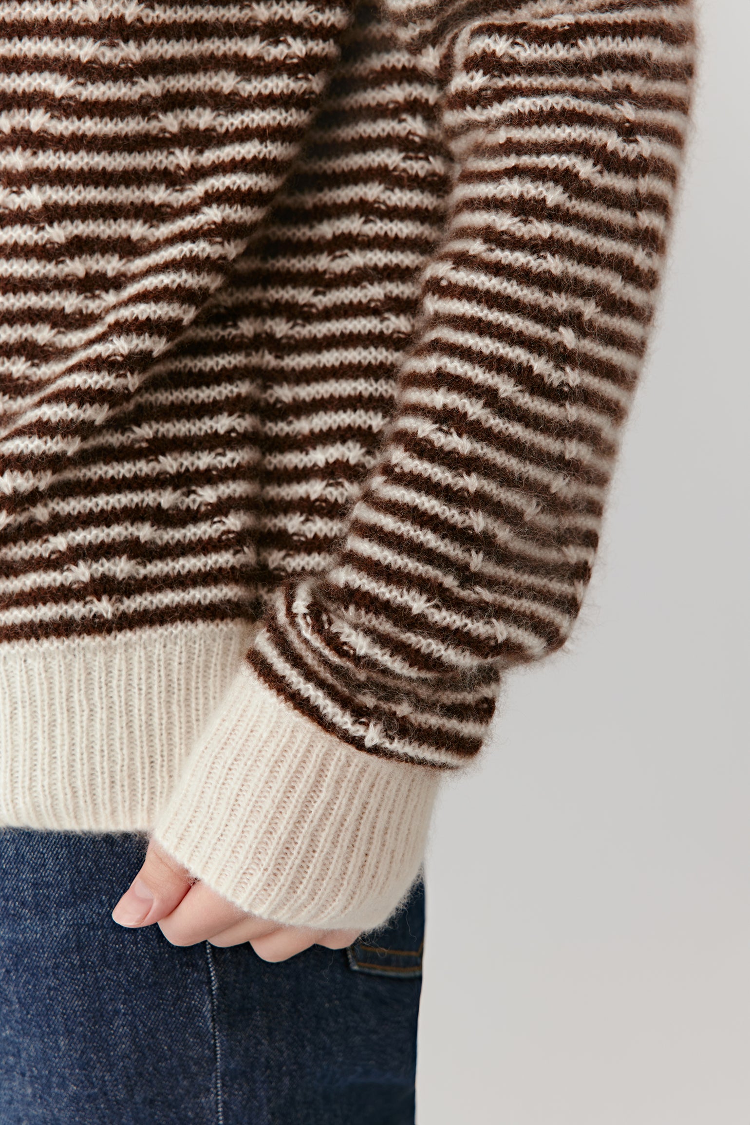 Detail close-up of the cardigan’s sleeve and button placket, showing the ribbed trim and refined knit texture.