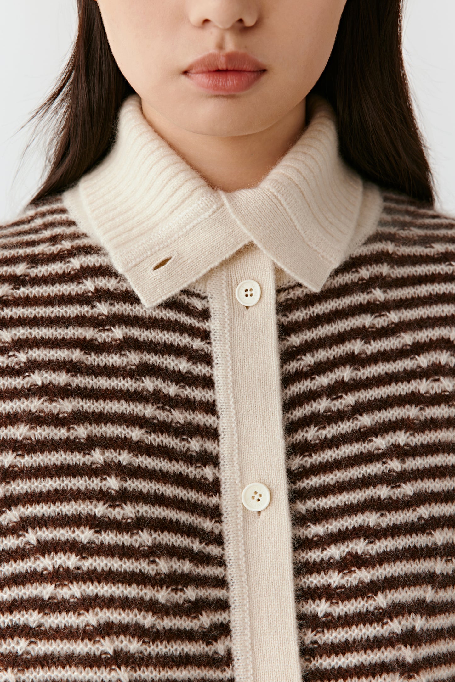 Close-up of the striped cashmere-silk cardigan featuring a contrasting cream pointed collar and brown-and-off-white striped knit.”