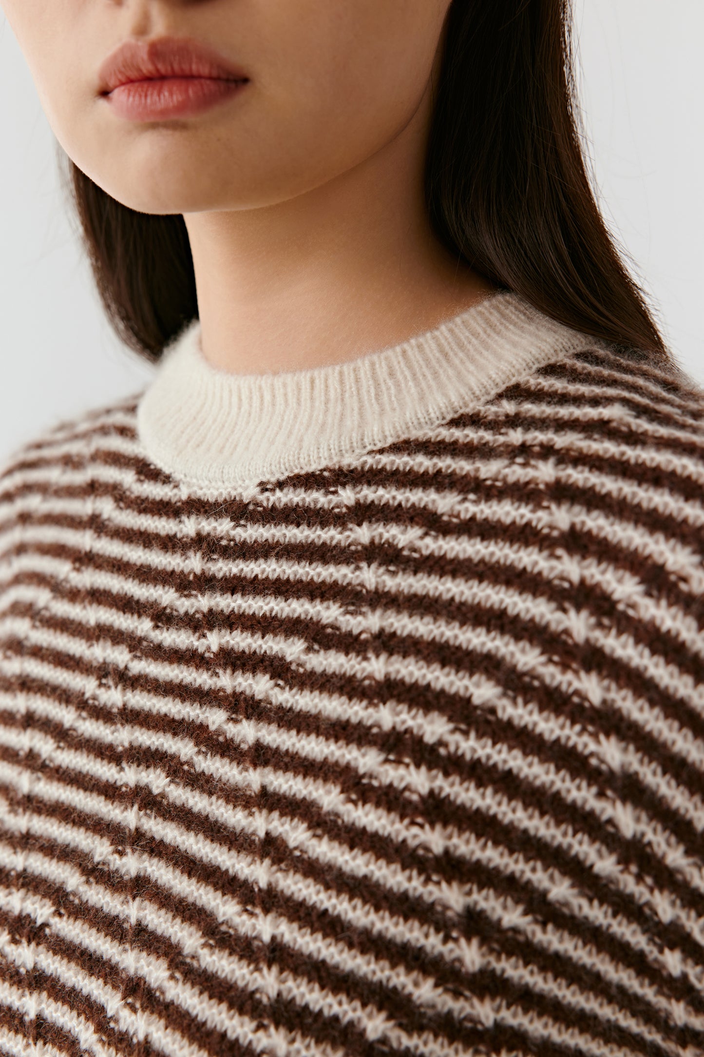 Side profile of the brown and off-white striped pullover, showing the straight cut and lightweight texture.