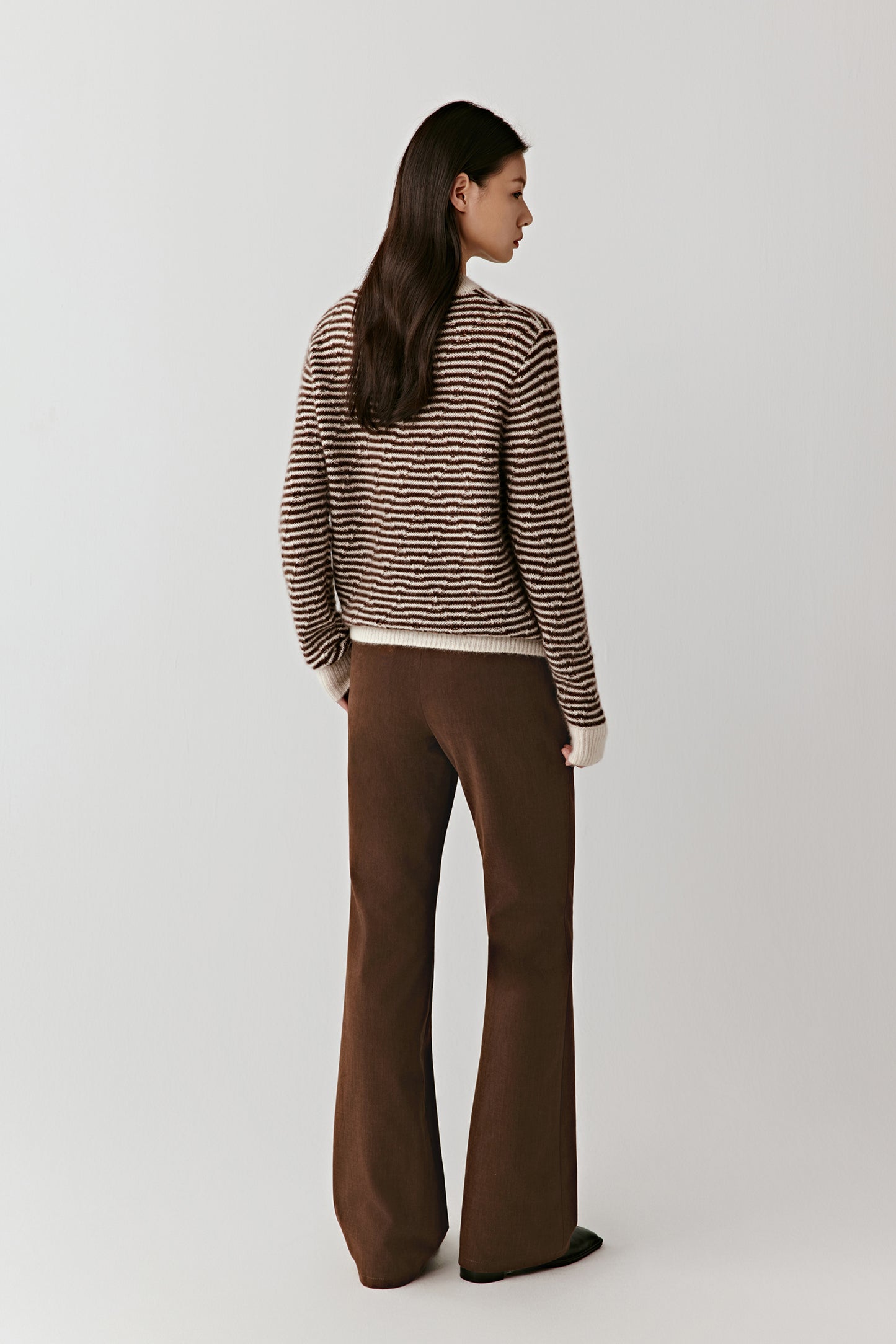 Side-angled full-length view of the striped pullover, highlighting the soft drape and clean lines of the knit