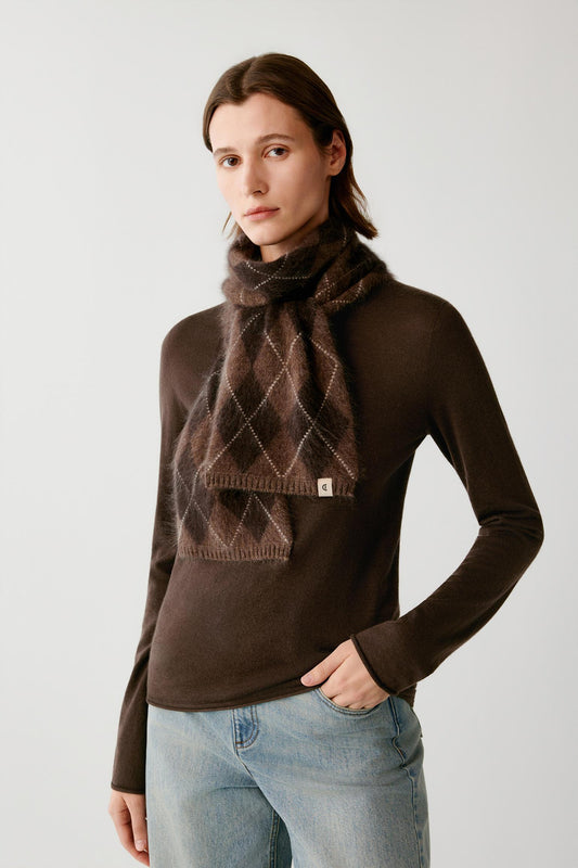 Front view of a woman wearing a dark brown brushed cashmere scarf with a contrasting argyle pattern.