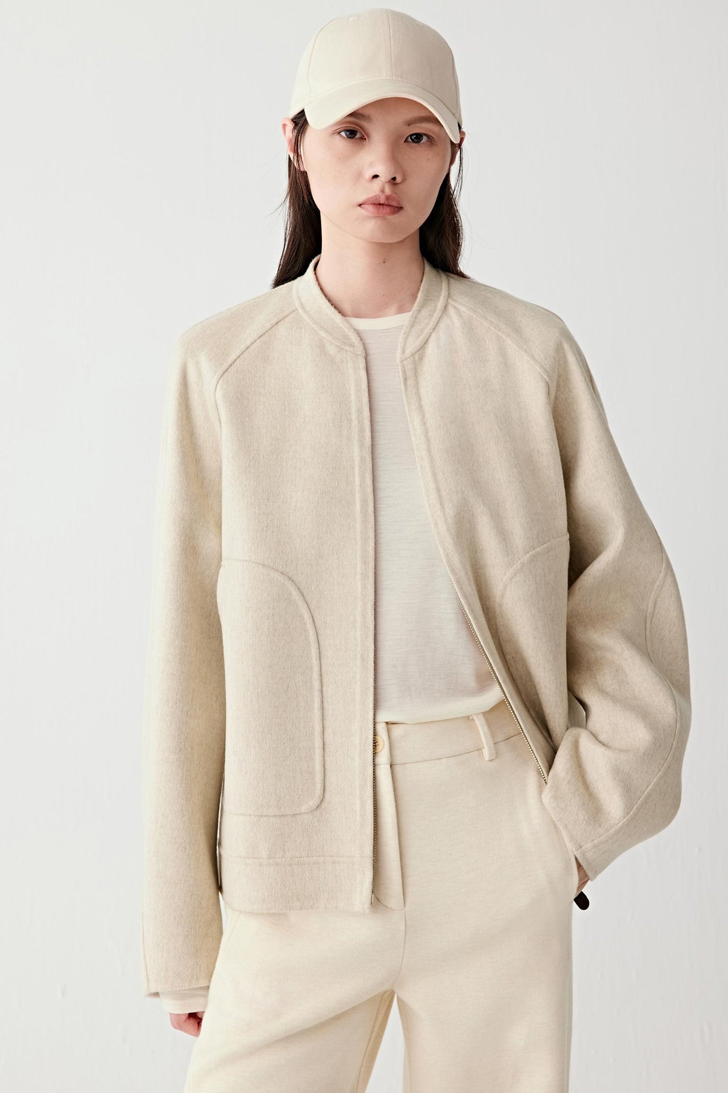 Three-quarter front view highlighting the soft volume, clean lines and understated tailoring of the jacket.
