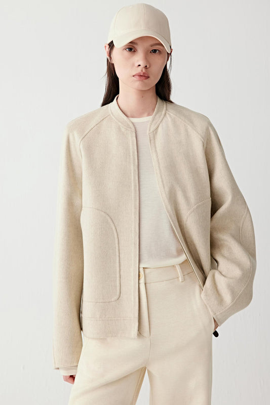 Three-quarter front view highlighting the soft volume, clean lines and understated tailoring of the jacket.