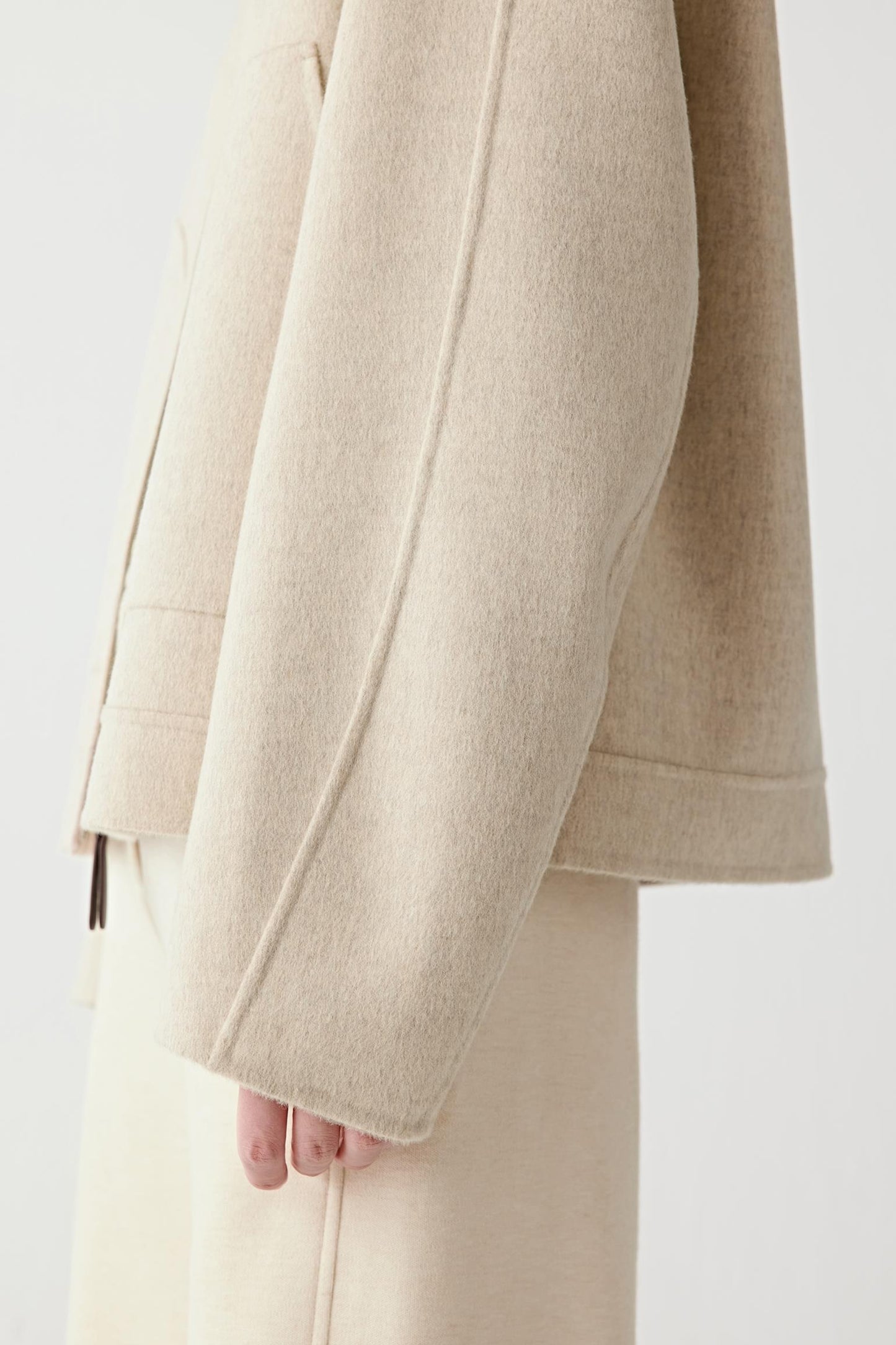 Close-up of the hem and fabric texture, emphasizing the natural fibres and brushed finish.