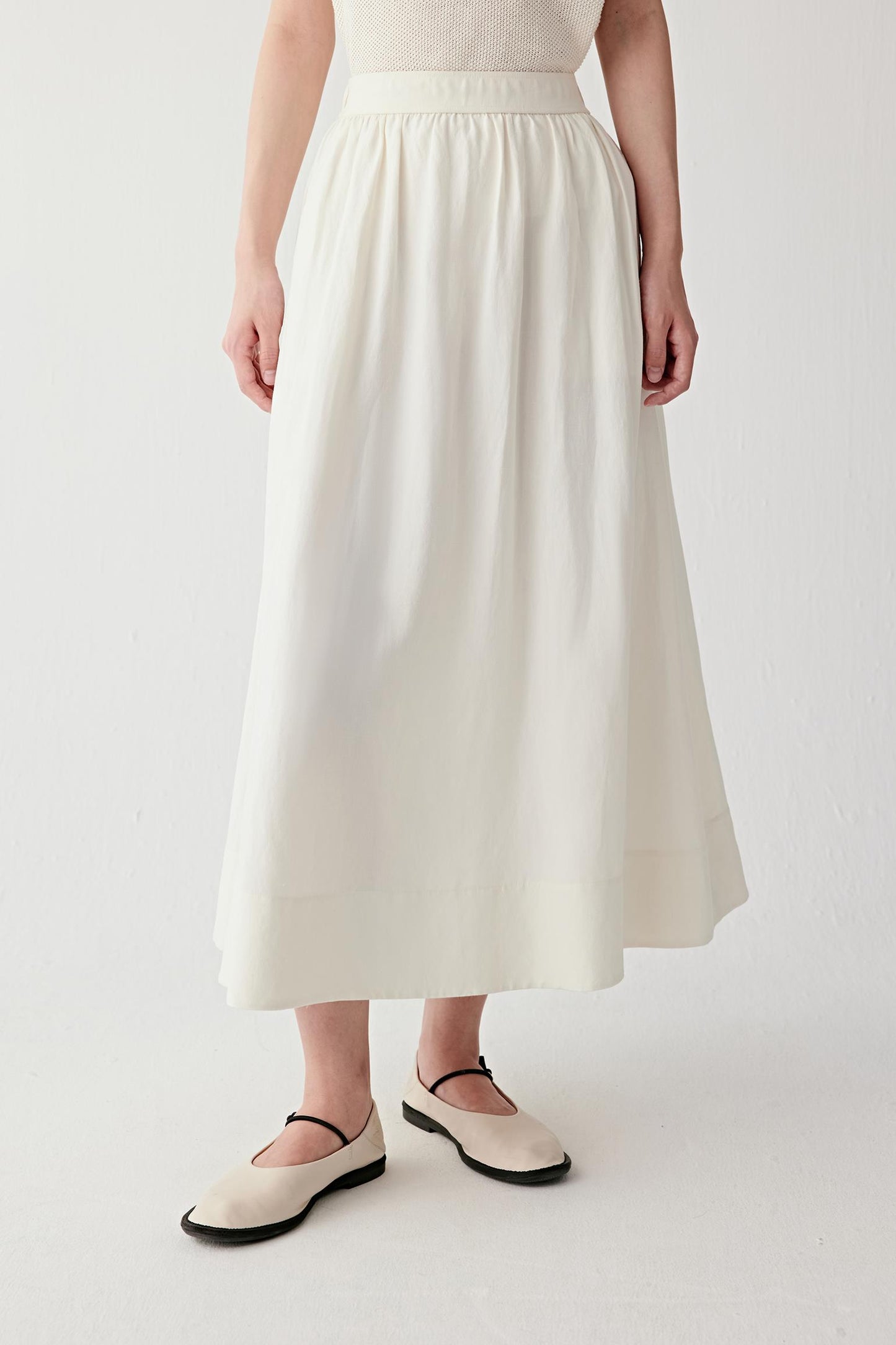 Front view emphasizing vertical fall, soft pleating from the waistband and lightweight texture