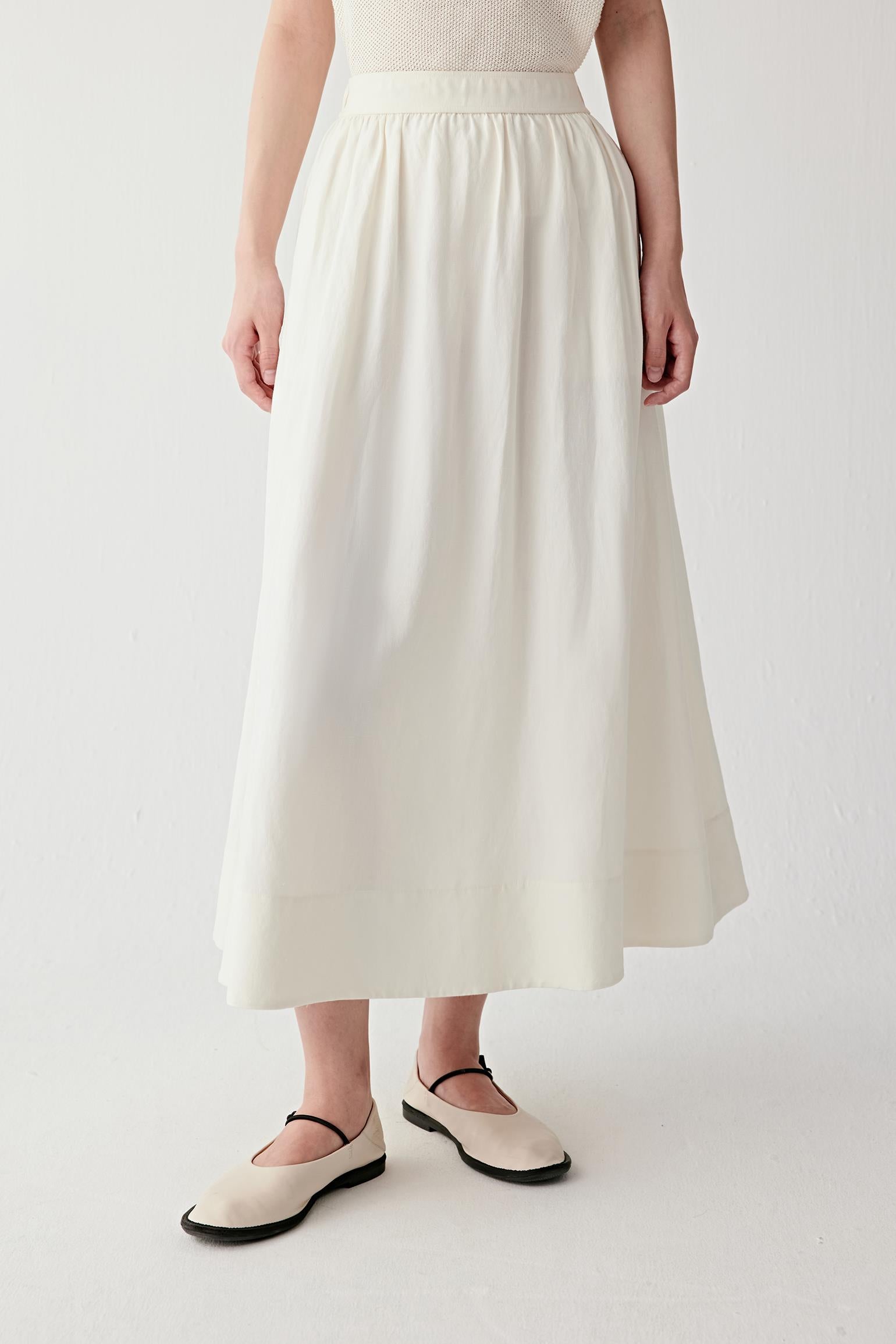 Front view emphasizing vertical fall, soft pleating from the waistband and lightweight texture