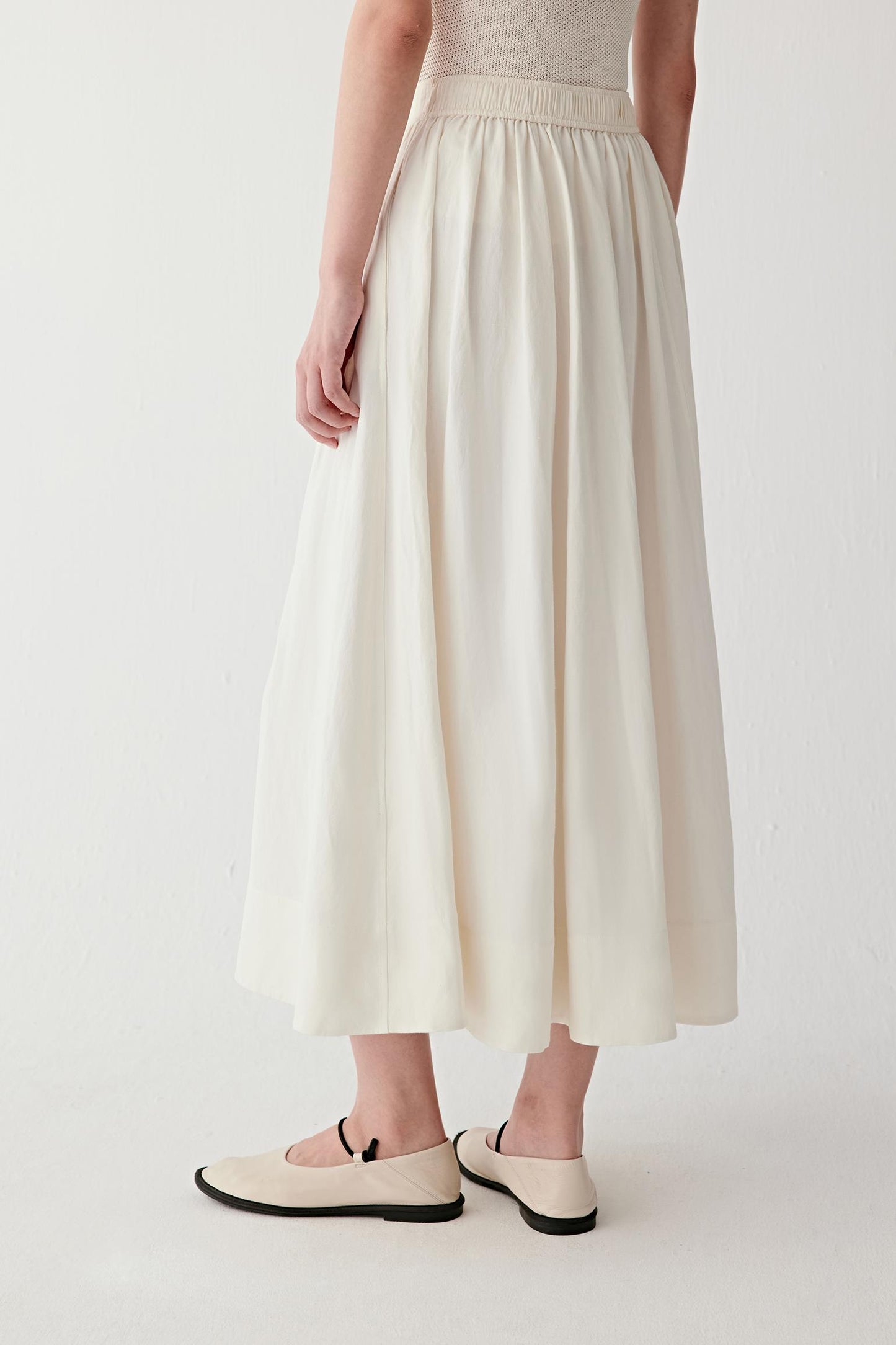 Side view showing how the skirt moves with the body, revealing volume distribution and fluid silhouette