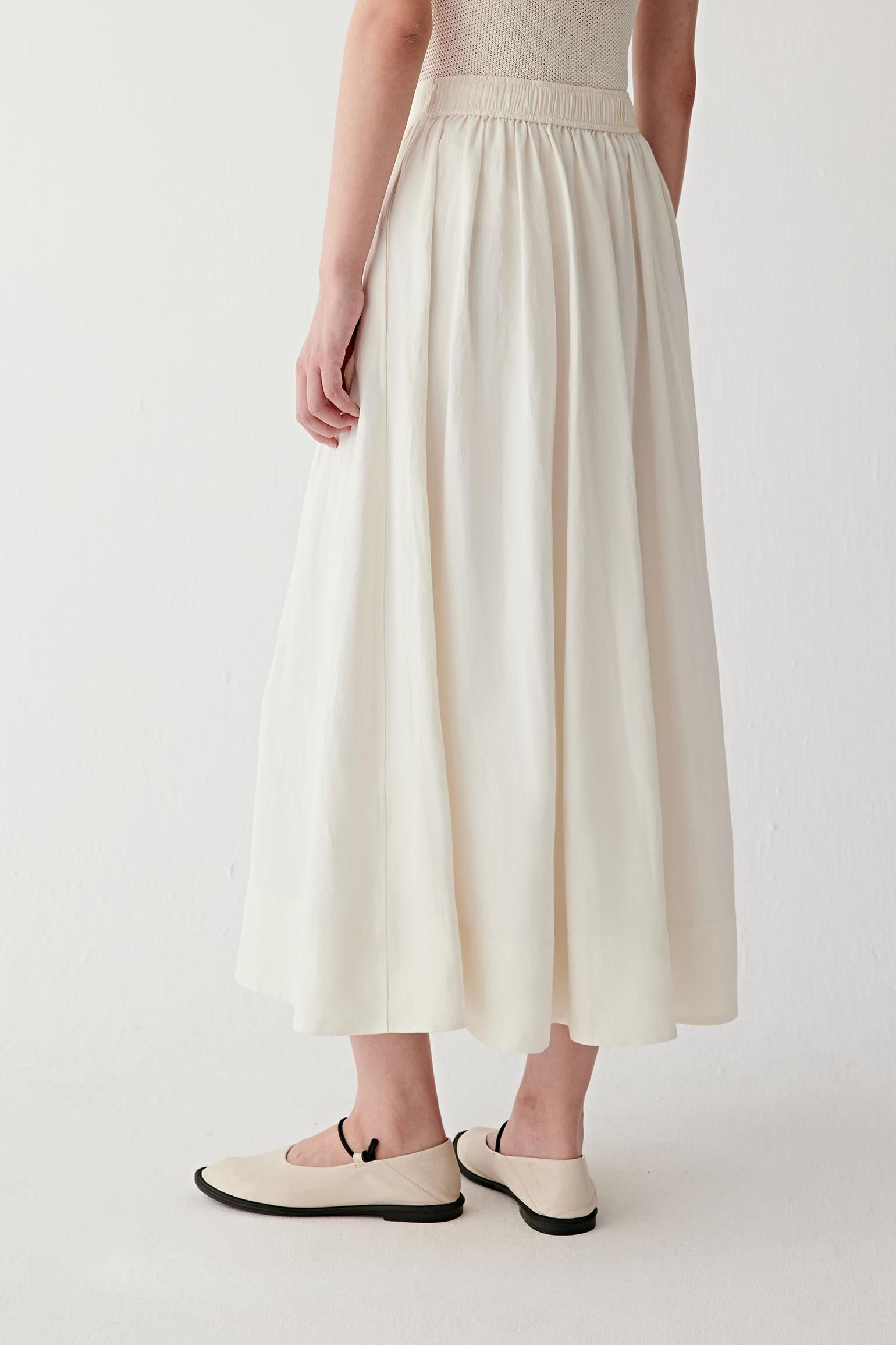 Side view showing how the skirt moves with the body, revealing volume distribution and fluid silhouette
