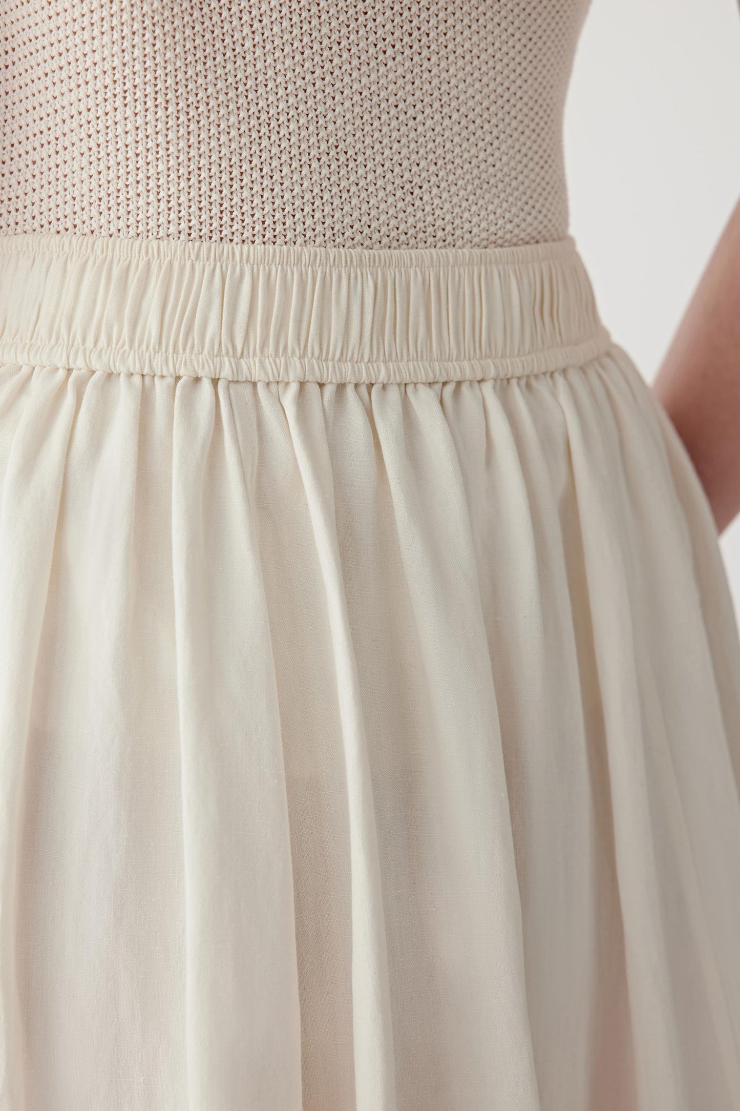 Close-up of fabric showing slightly textured silk-linen blend, matte surface and airy weave