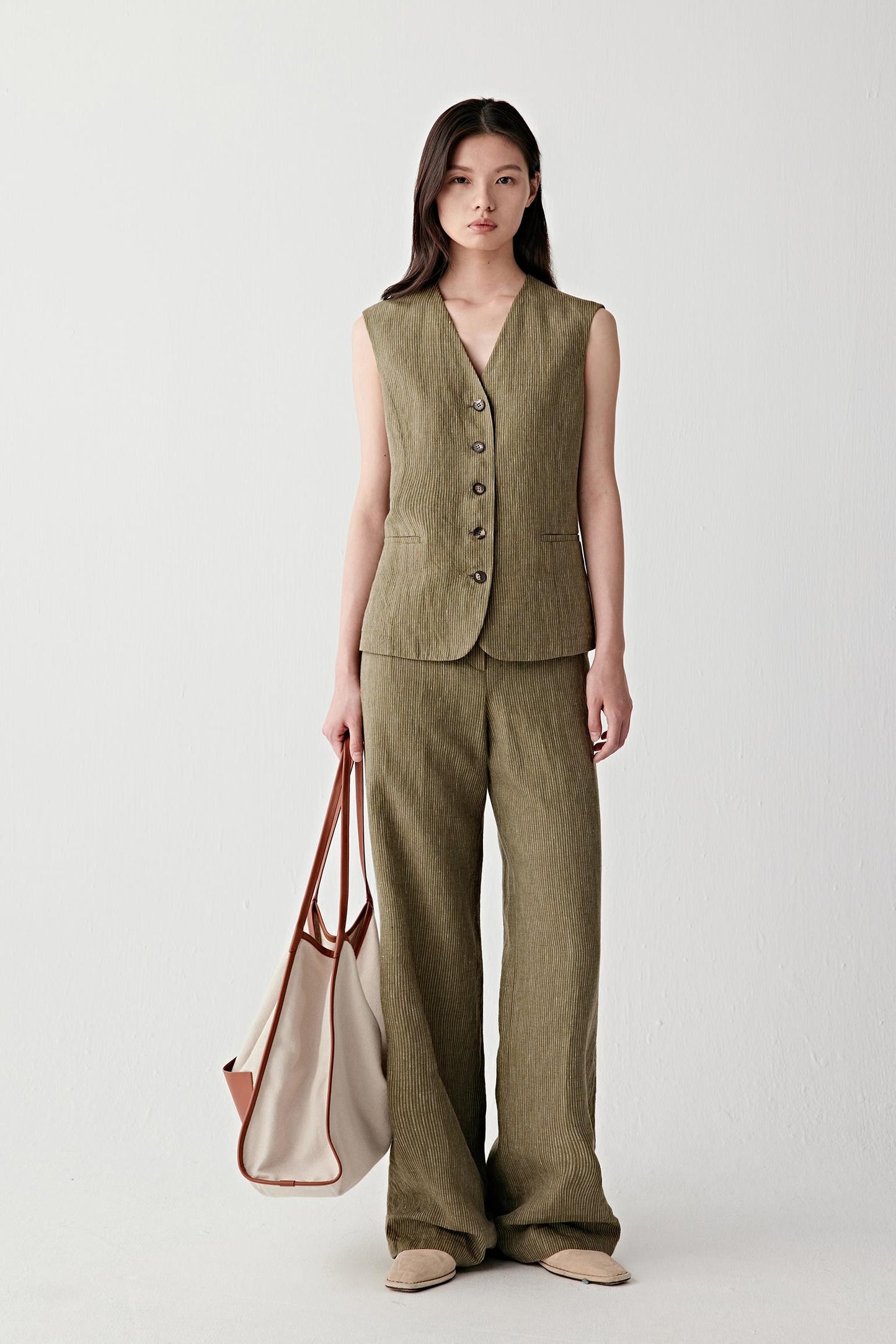 Full-length front view showing the vest styled with matching striped trousers, emphasizing the coordinated set, the straight fall of the garment from shoulders to hem and the clean, structured lines created by the tailored cut