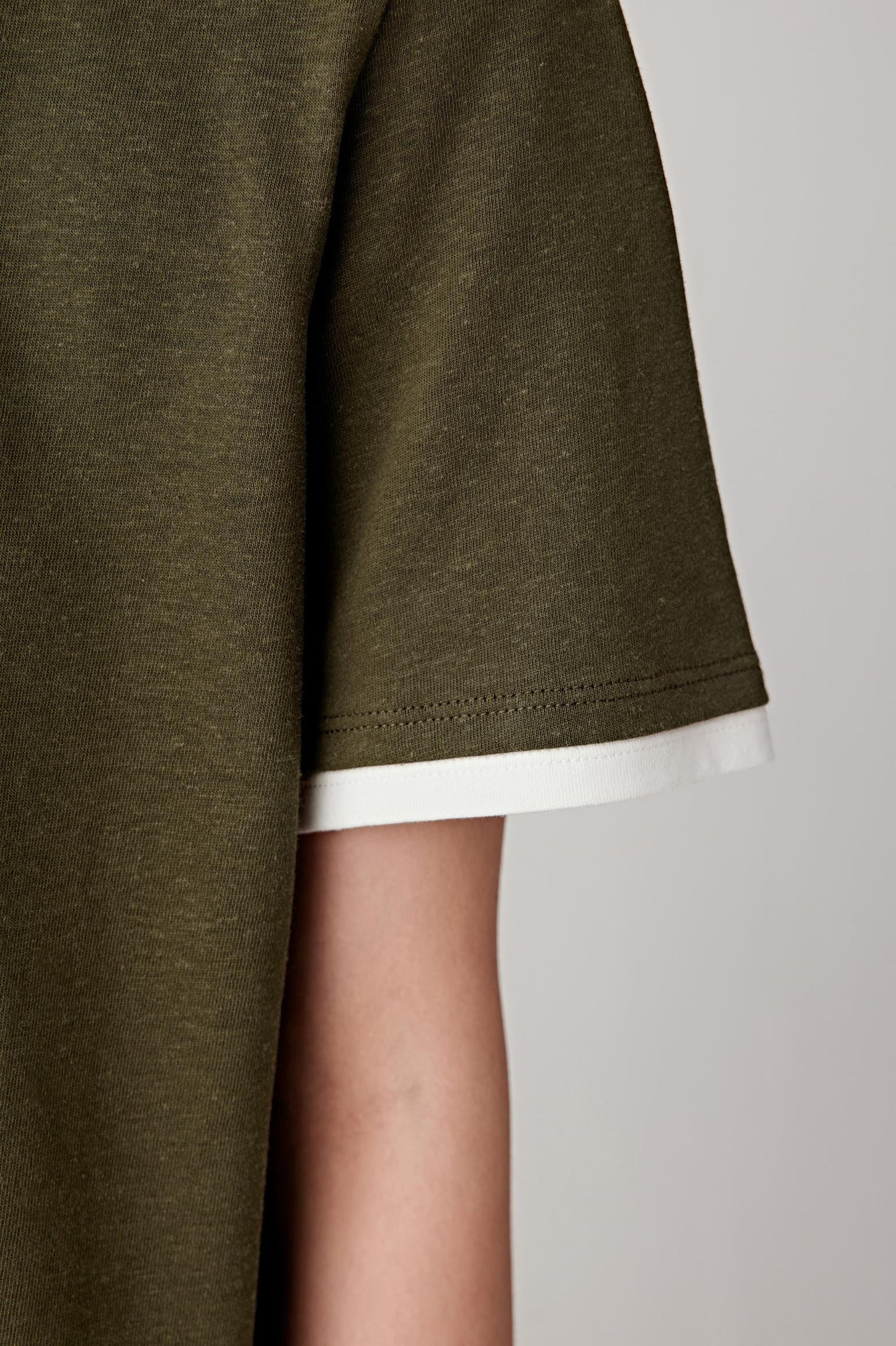 Close-up of sleeve hem showing edge finishing, thickness of jersey knit and soft structure