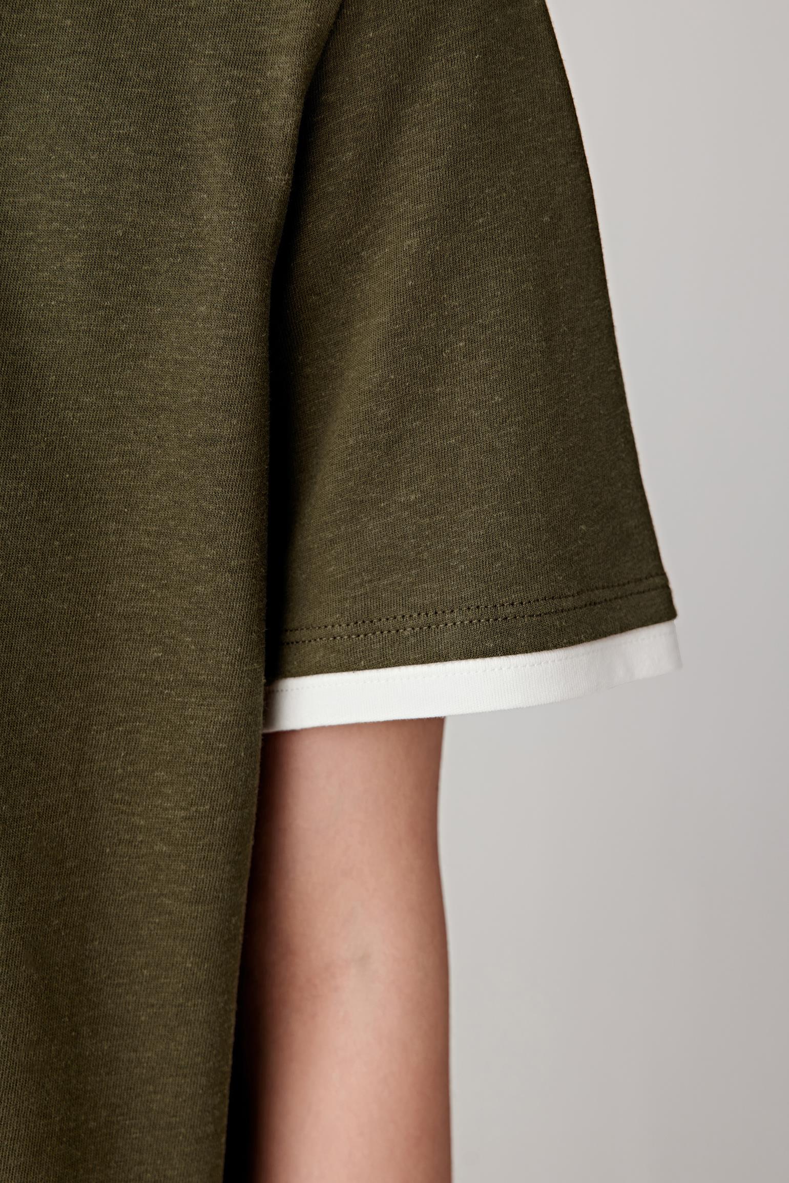 Close-up of sleeve hem showing edge finishing, thickness of jersey knit and soft structure