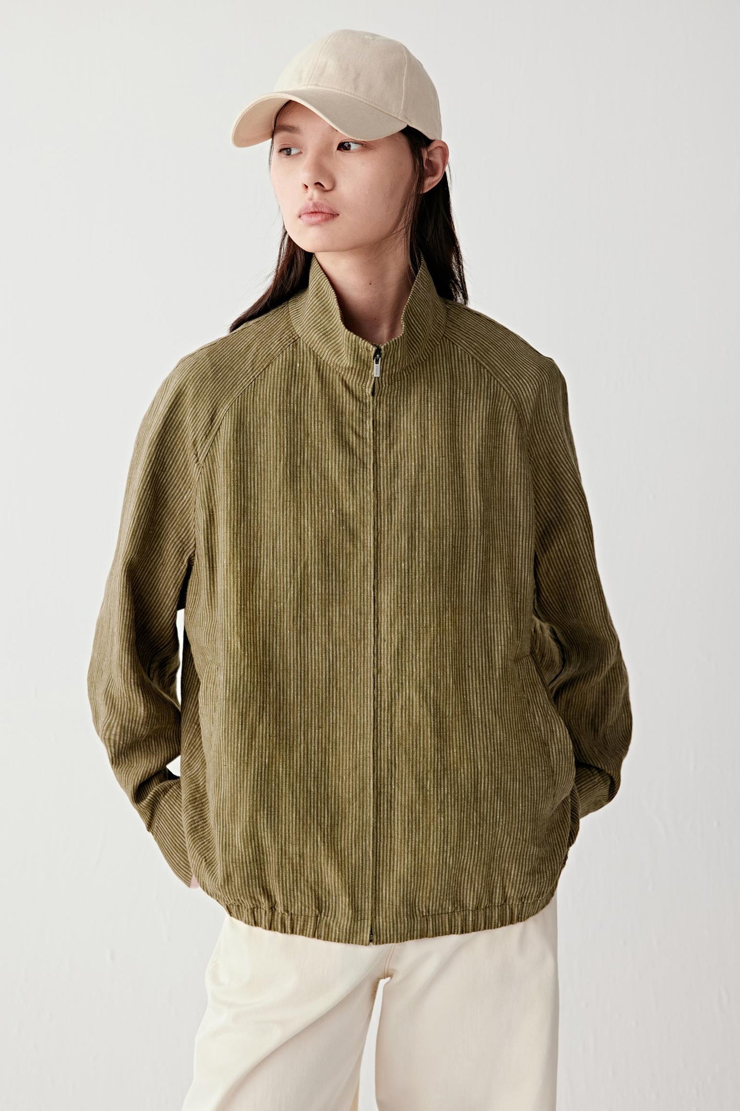 Mid-length front view showing button fastening, collar shape and textured woven surface
