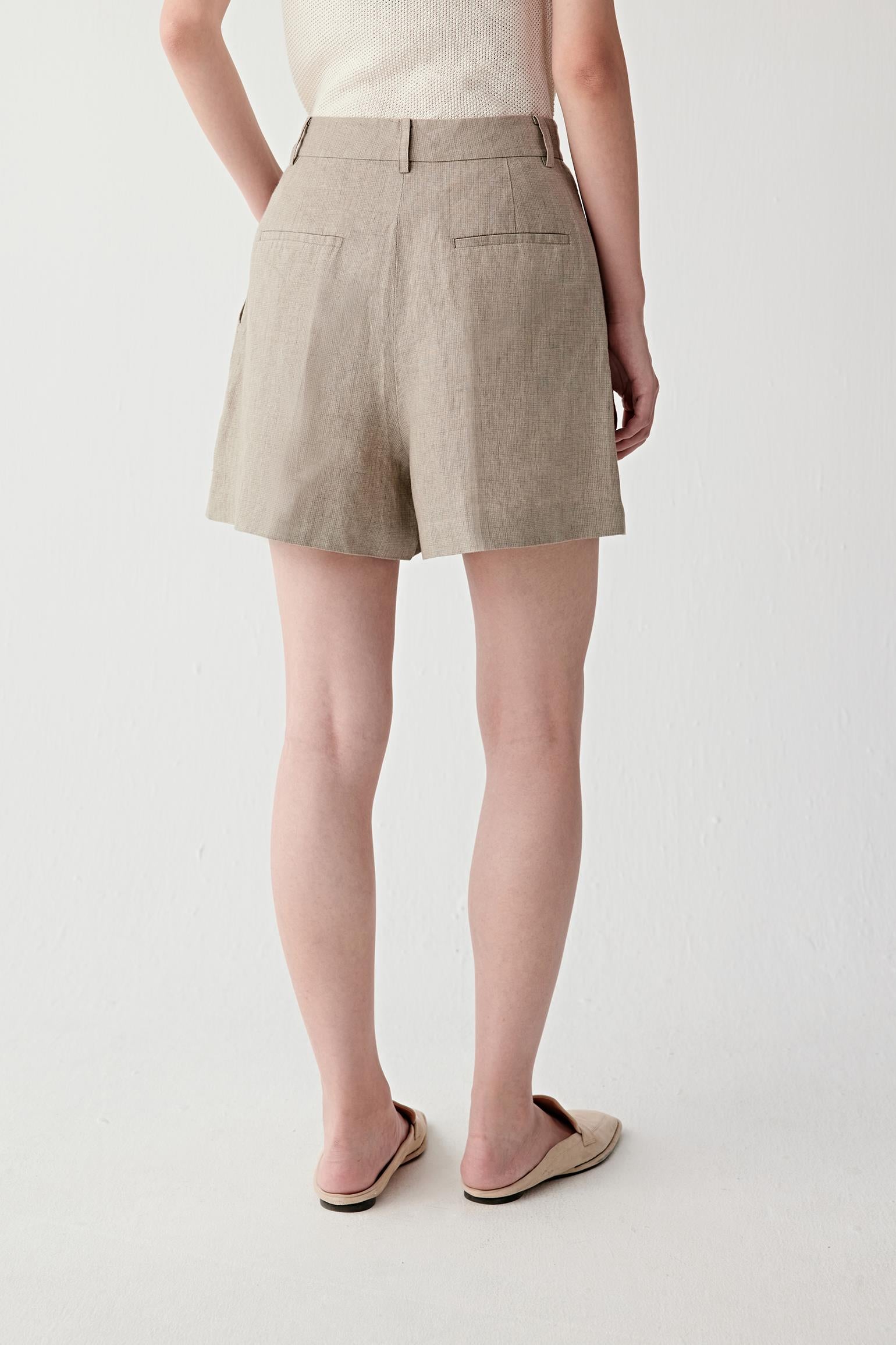 Side or back view highlighting the clean line of the shorts, side and back welt pockets and the softly structured silhouette