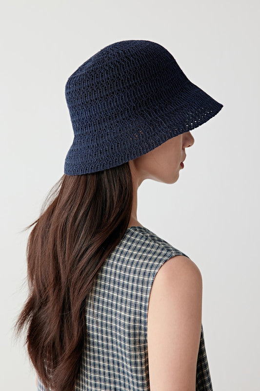 Side profile view showing the bucket hat from the side, emphasizing the downward-sloping brim, flexible edge and textured knit surface with slight openness in the structure