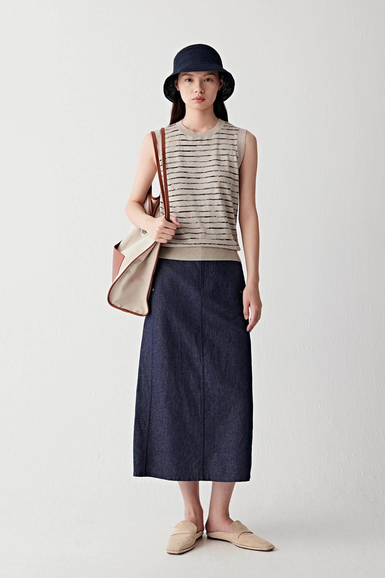 Full-length front view highlighting vertical balance, sleeveless cut and interaction with dark skirt
