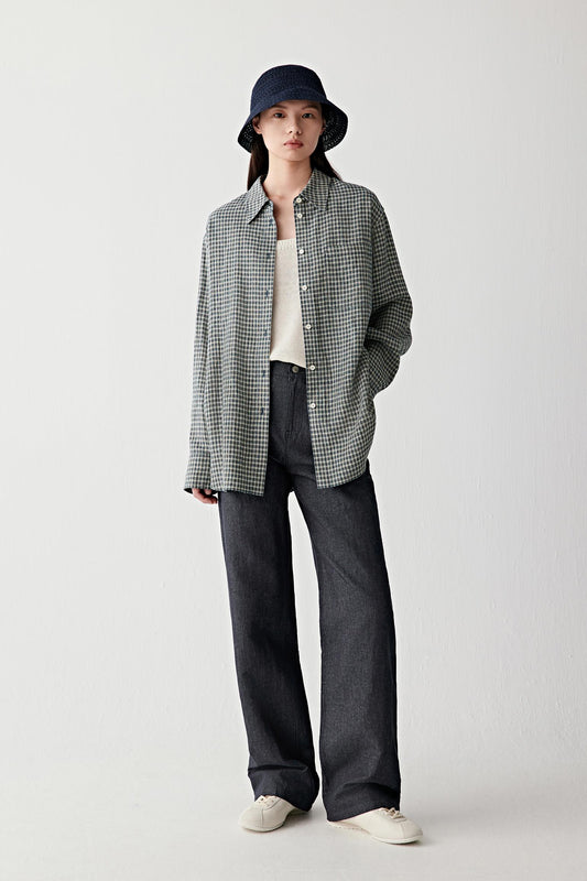 Full-length front view of a woman standing facing forward wearing navy blue hemp and cotton twill straight-leg trousers, styled with a lightweight jacket and bucket hat, highlighting the clean straight silhouette, mid-rise waist and the structured yet soft drape of the twill fabric