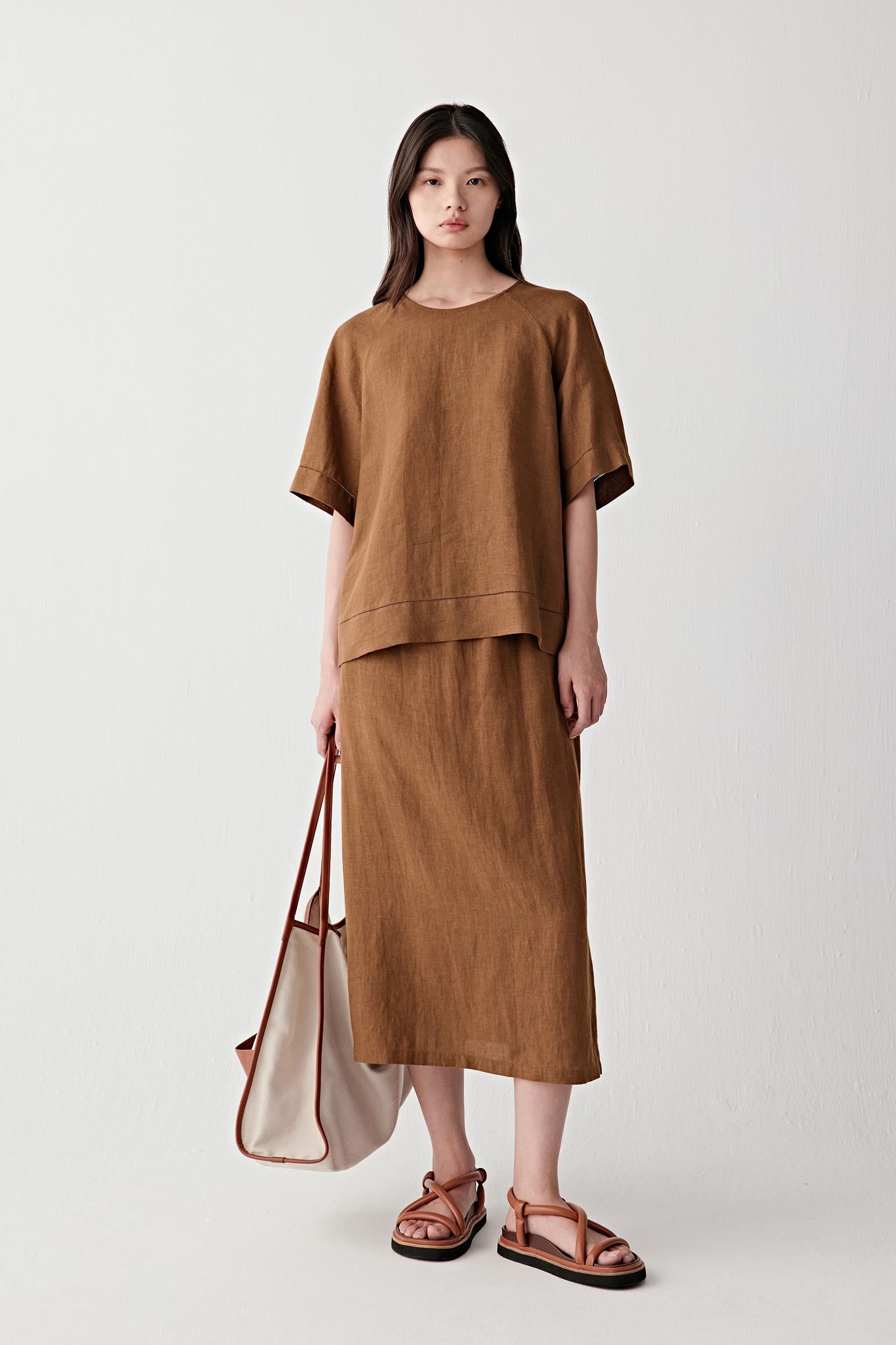 Full-length front view showing the top paired with a matching skirt, emphasizing the straight cut, lightweight structure and ease of movement created by the linen fabric