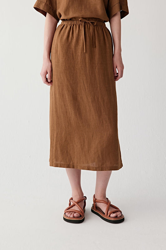 Mid-length front view focusing on the skirt from waist to hem, emphasizing the gathered elasticated waistband, drawstring detail and softly flowing volume through the lower silhouette