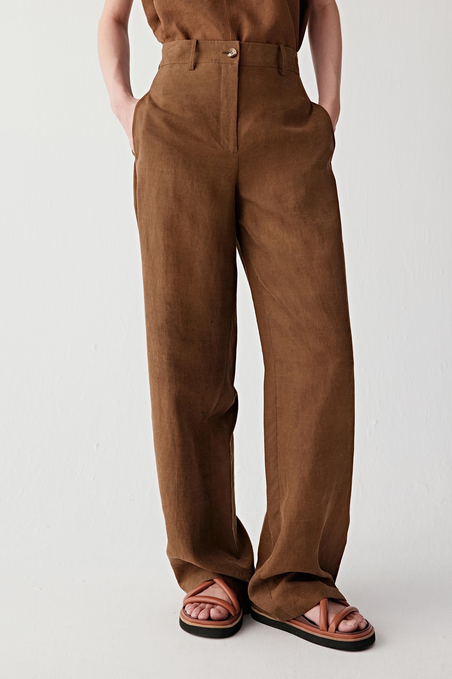 Front or three-quarter view emphasizing the wide-leg silhouette, fitted waistband and elongated line, showing the soft movement and compact woven structure of the fabric
