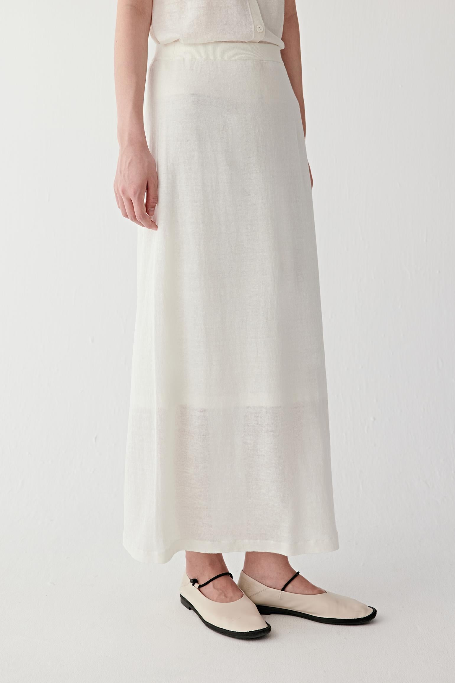 Close-up of waistband detailing the ribbed waistband construction, clean stitching and lightly textured off-white fabric surface with natural irregularity