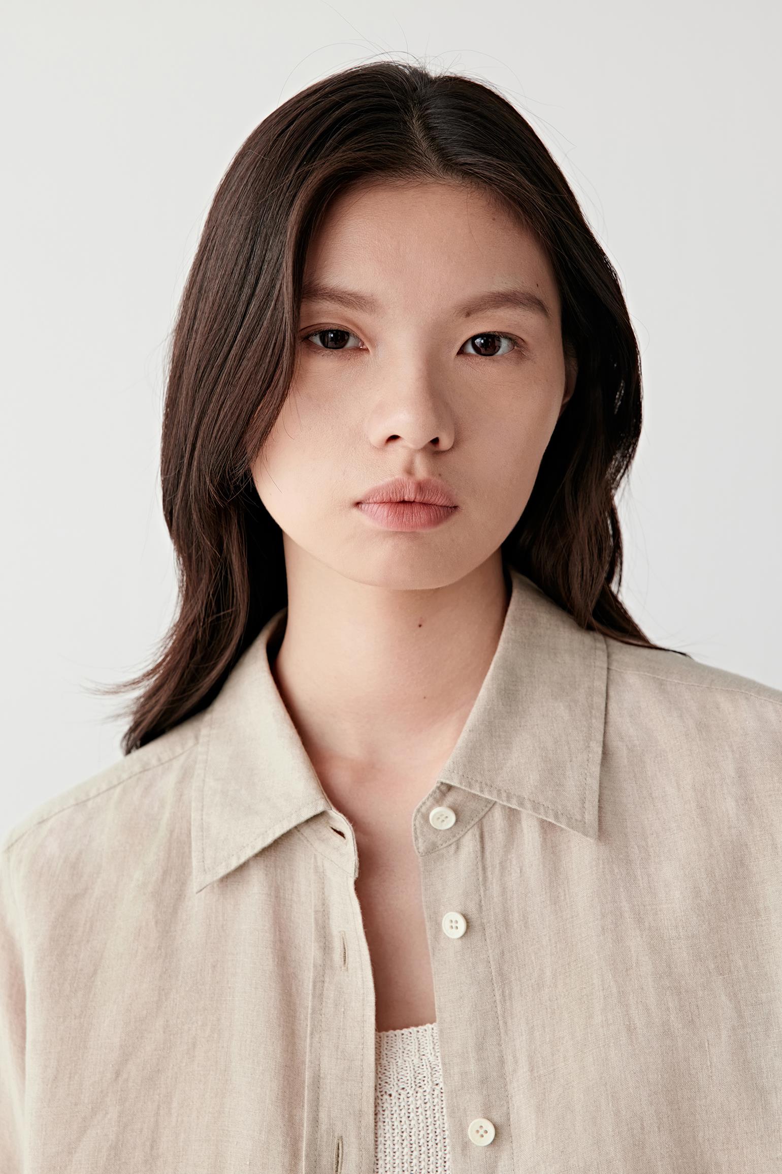 Close-up portrait focusing on the classic collar and front fastening, detailing the lightly textured melange weave and soft matte finish