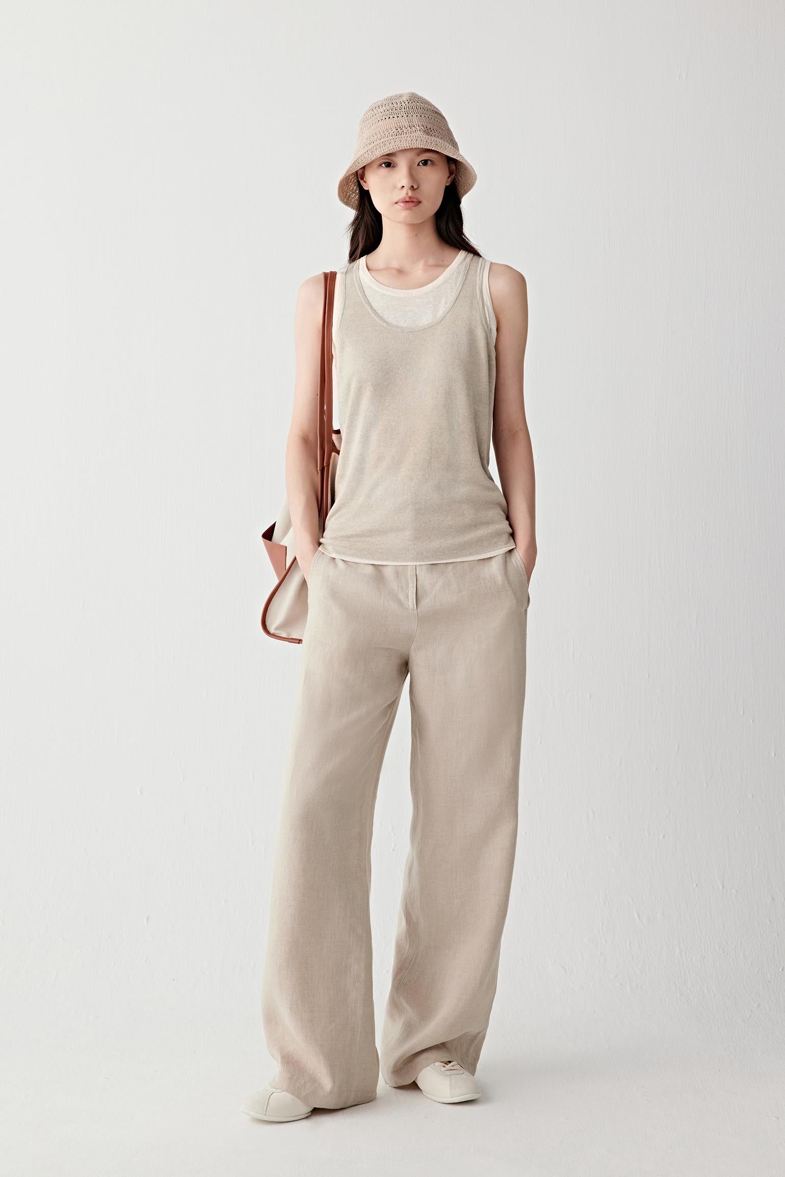 Front or three-quarter view emphasizing the sleeveless cut and layered neckline construction, showing the soft movement of the fine knit fabric