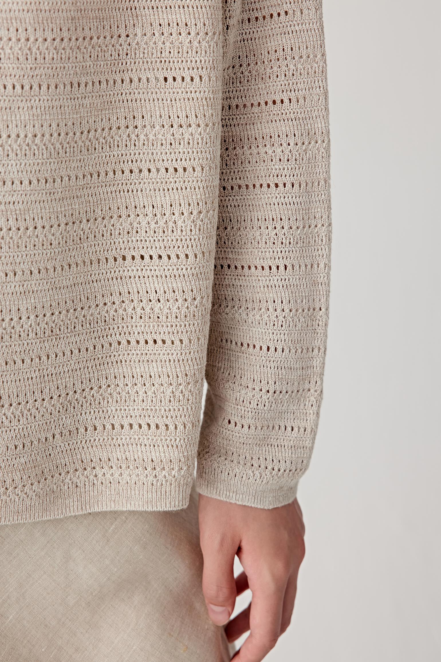 Close-up of sleeve and cuff showing the ribbed trim, openwork knit texture and lightweight construction of the linen and silk cardigan