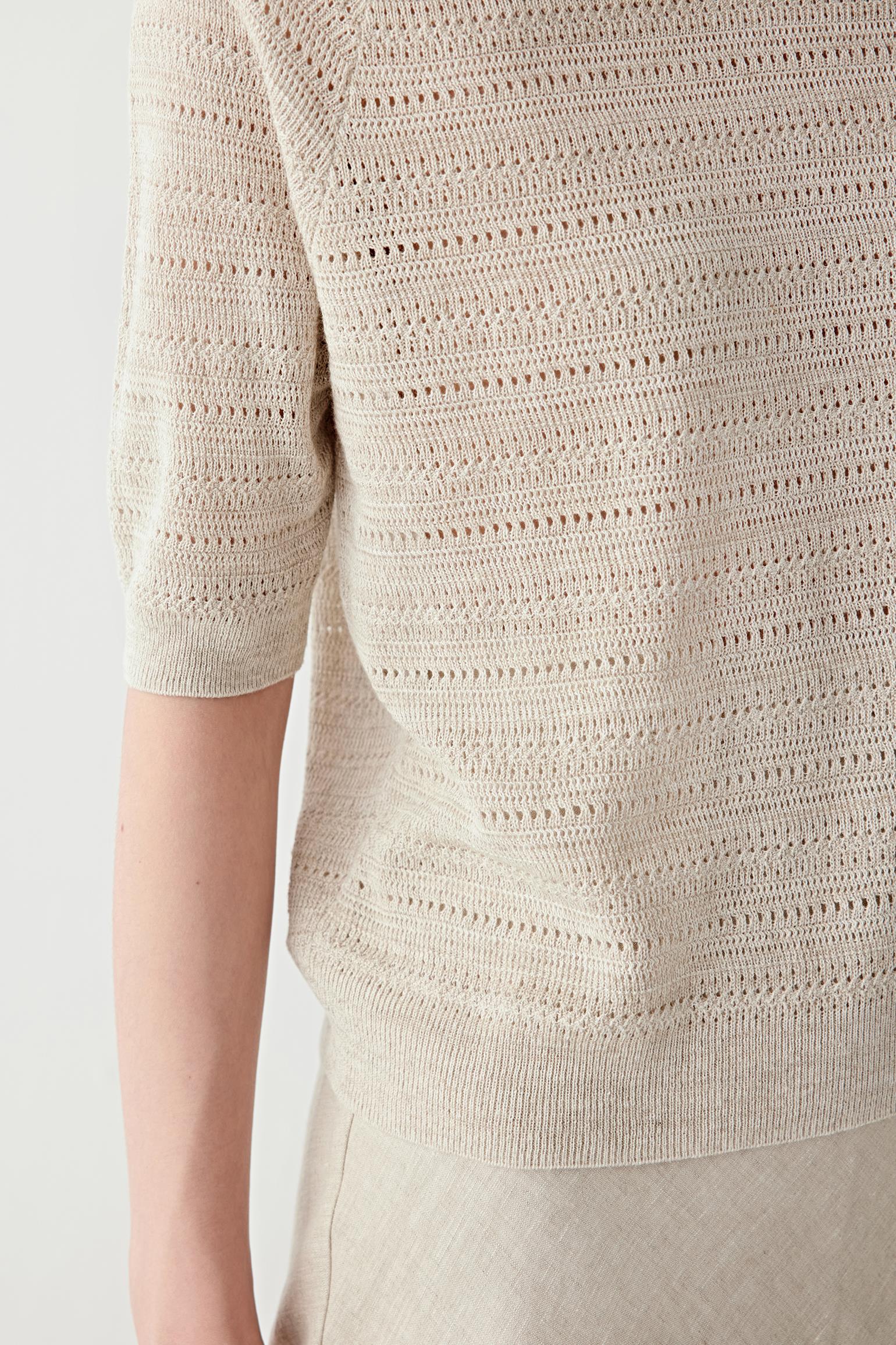 Close-up of sleeve and ribbed trim showing the openwork construction, ribbed finishing and subtle irregularities of the linen and silk yarn blend