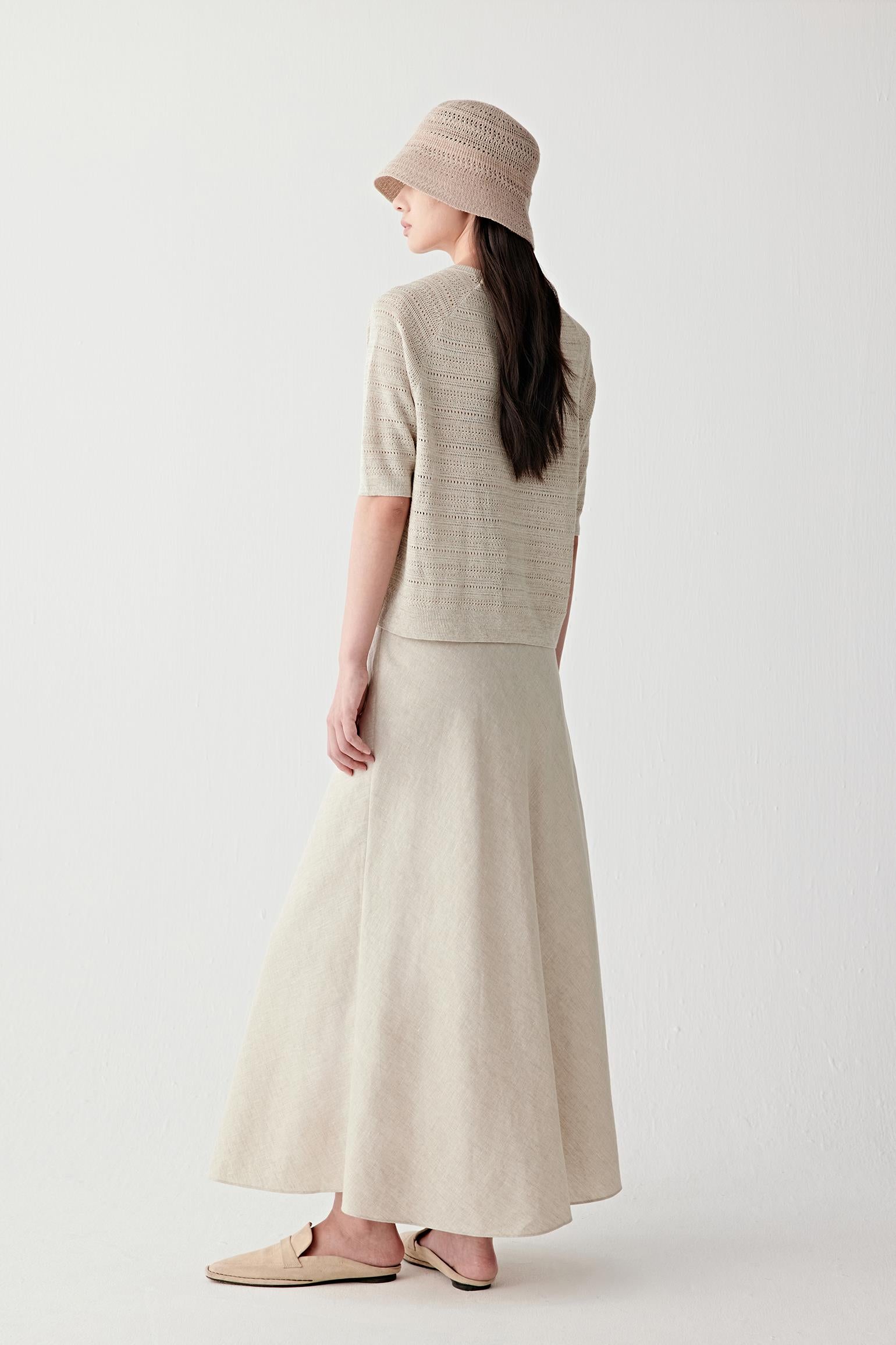 Side or back view highlighting the fluid drape and lightweight openwork structure through the body and sleeves