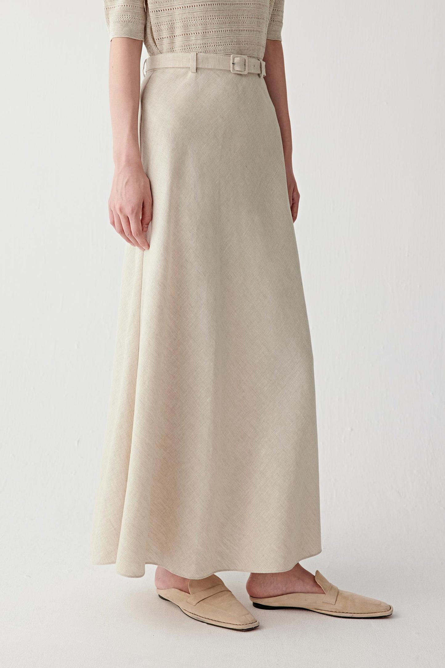 Close-up of waistband and belt detailing the wide waistband, matching fabric belt and visible stitching, highlighting the textured woven structure and natural irregularities of linen